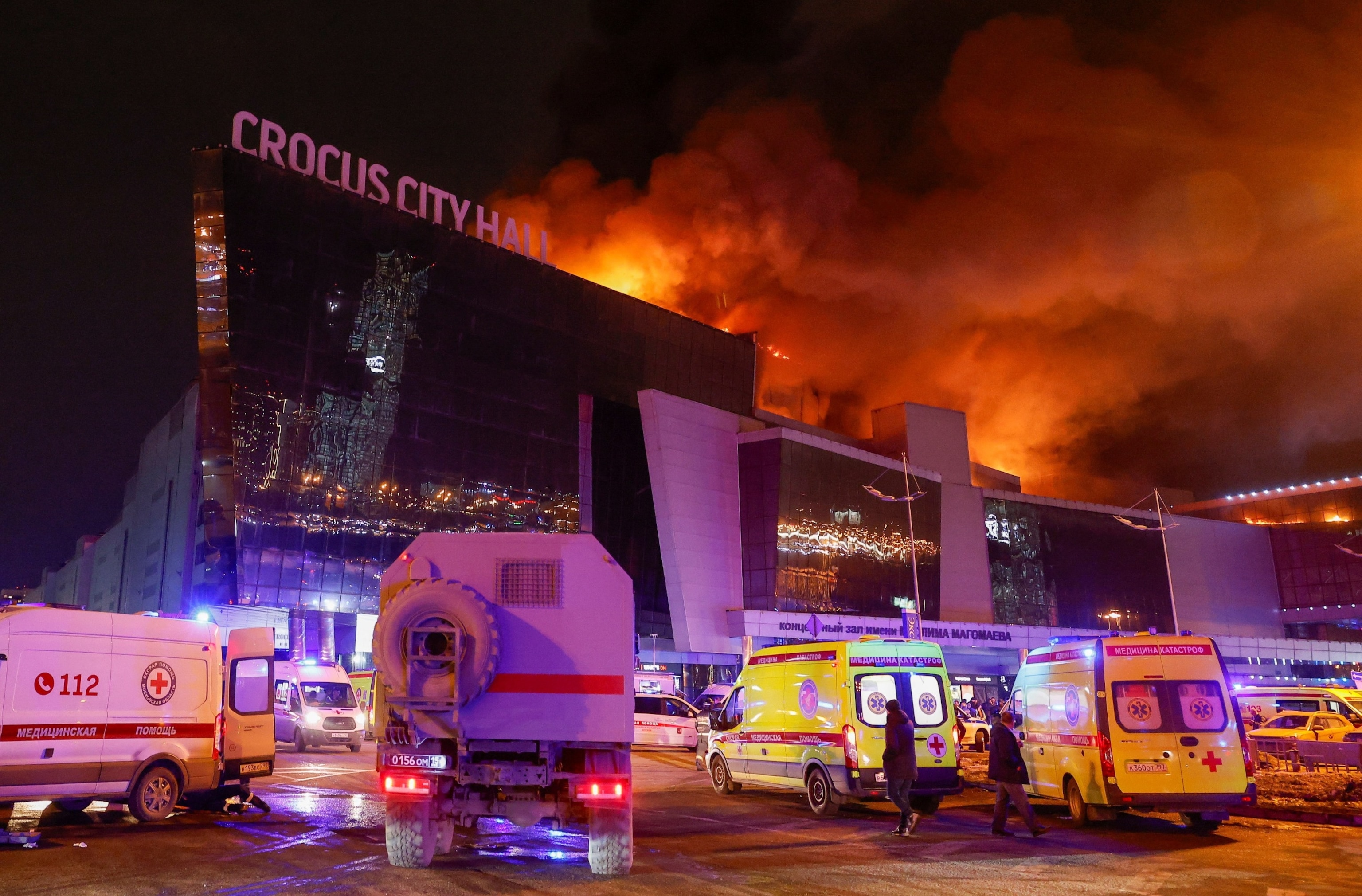 PHOTO: Vehicles of Russian emergency services are parked near the burning Crocus City Hall concert venue following a reported shooting incident, outside Moscow, March 22, 2024. 