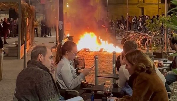 French Diners Enjoy Wine Amidst Nearby Protester-Set Fire: A Visual Account