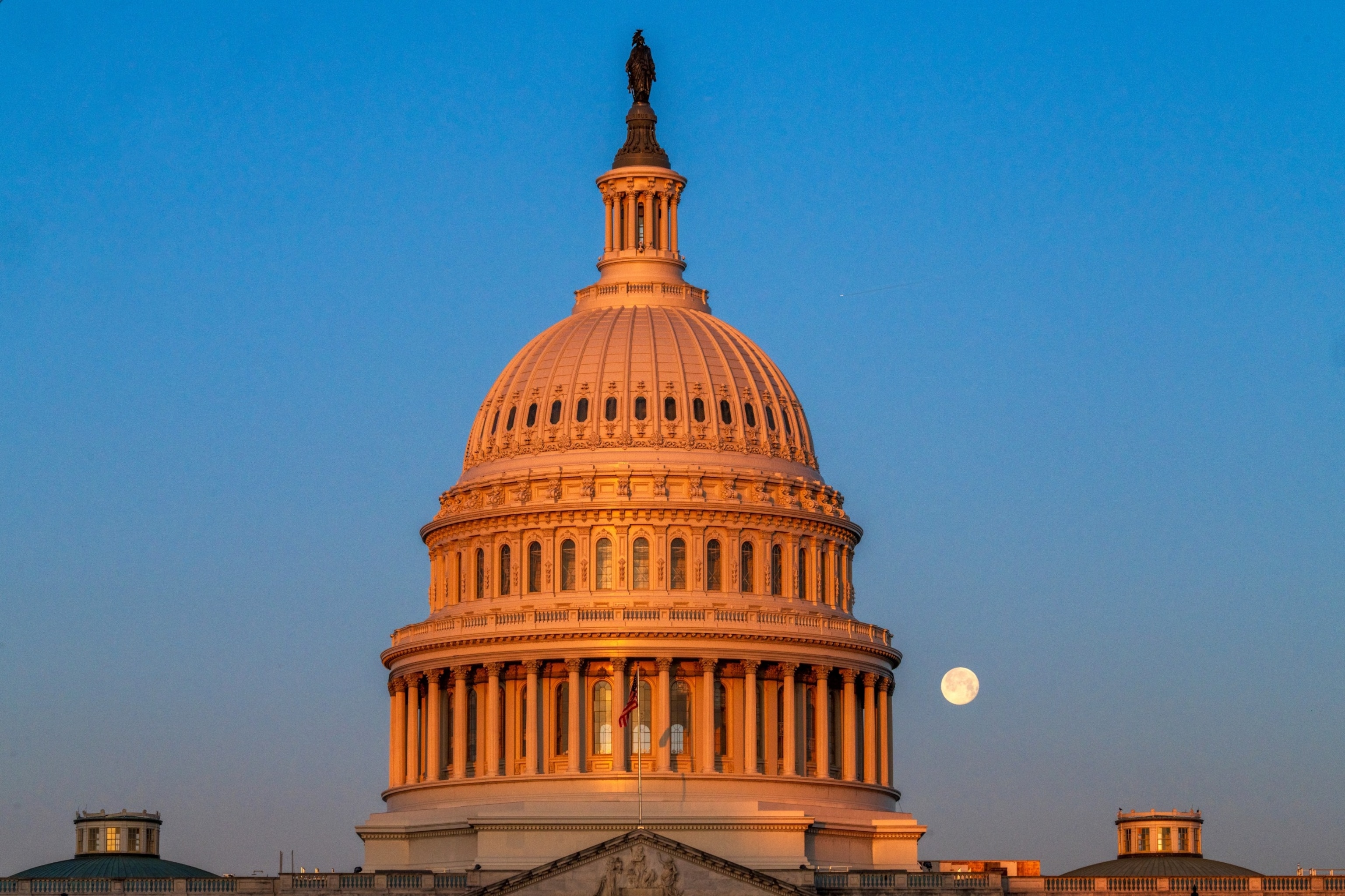 PHOTO: The Snow Moon sets behind the US Capitol Dome on February 25, 2024, in Washington, DC.