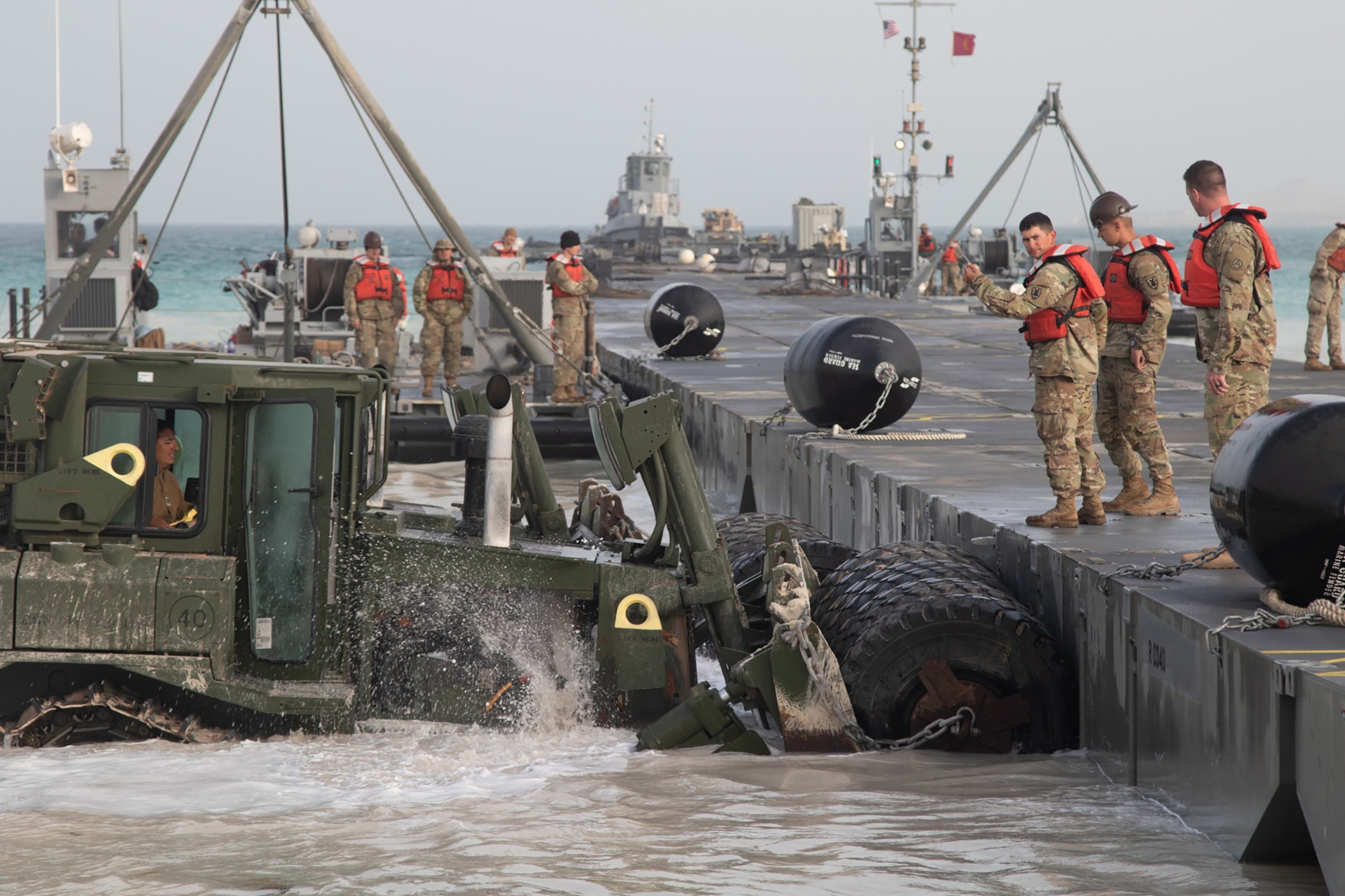 PHOTO: U.S. Army soldiers along with U.S. Navy Seabees align the Modular Causeway System of the Trident Pier in preparation for Iron Union 13 and Native Fury 20 in the United Arab Emirates, Mar 9, 2020.
