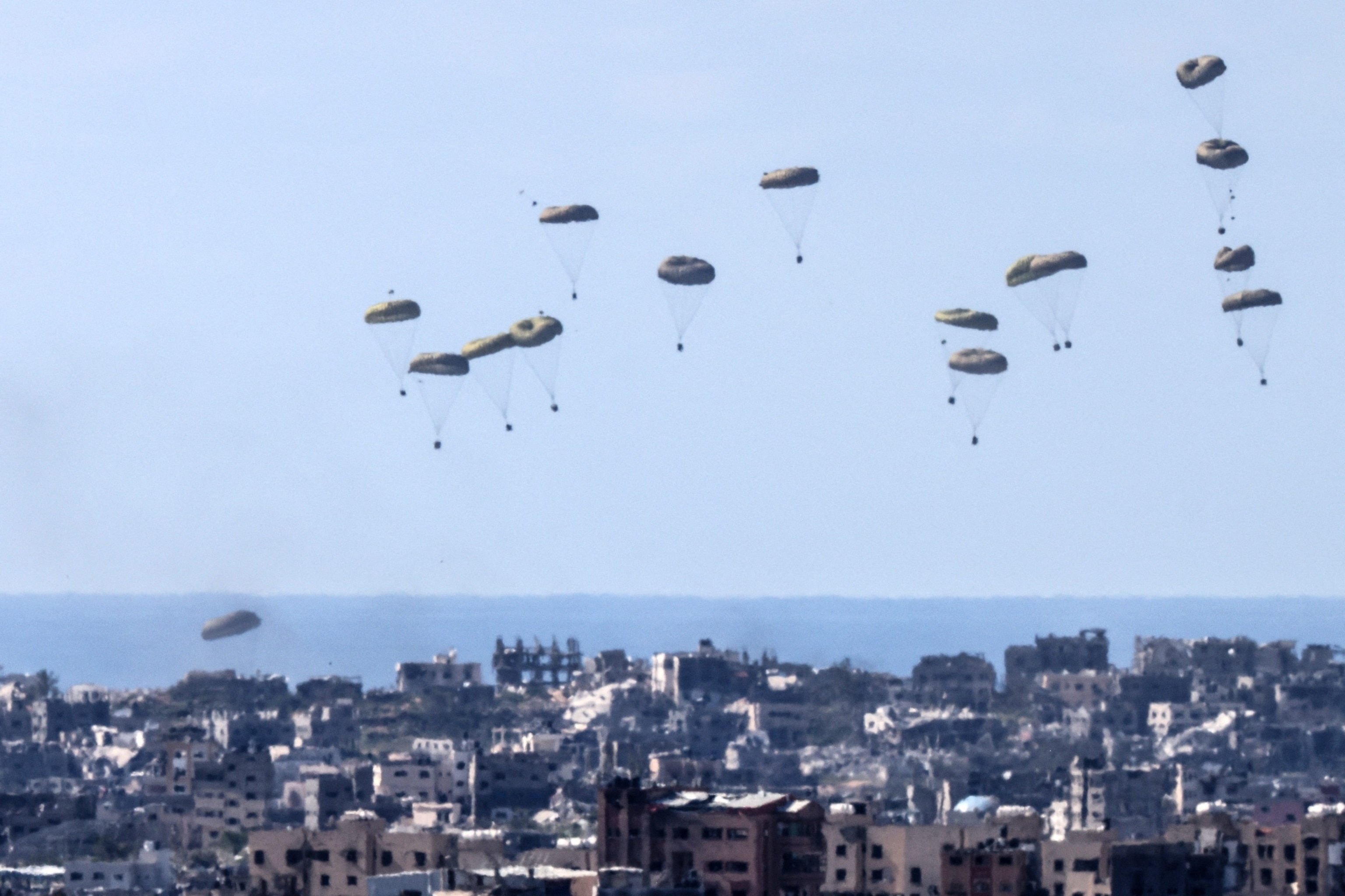 PHOTO: Humanitarian aid is airdropped by a military transport aircraft above the northern Gaza Strip, as seen from the Israeli side in southern Israel, Mar. 10, 2024.

