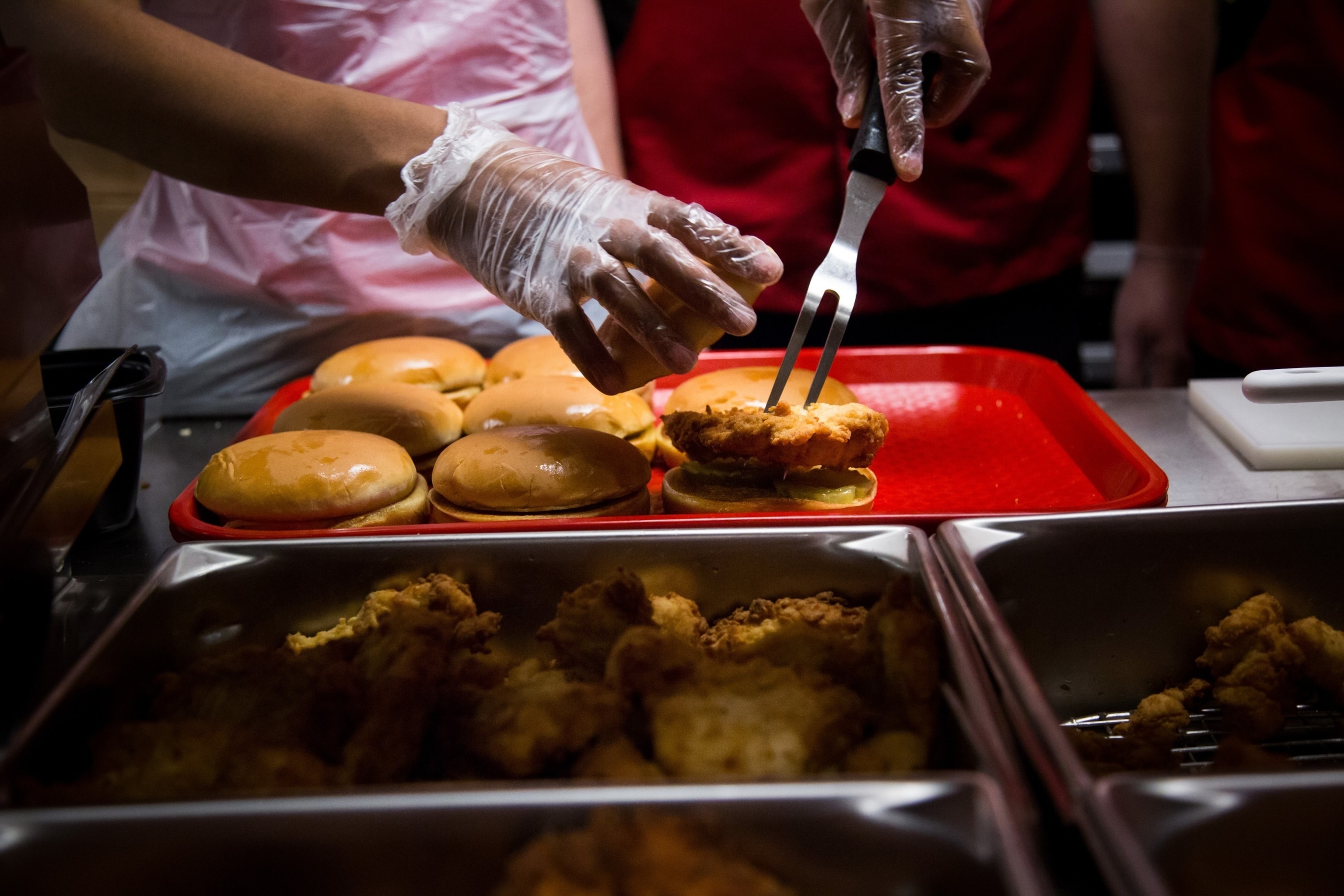 PHOTO: Employees prepare fried chicken sandwiches for guests during an event ahead of the grand opening for a Chick-fil-A restaurant in New York, Oct. 2, 2015. 