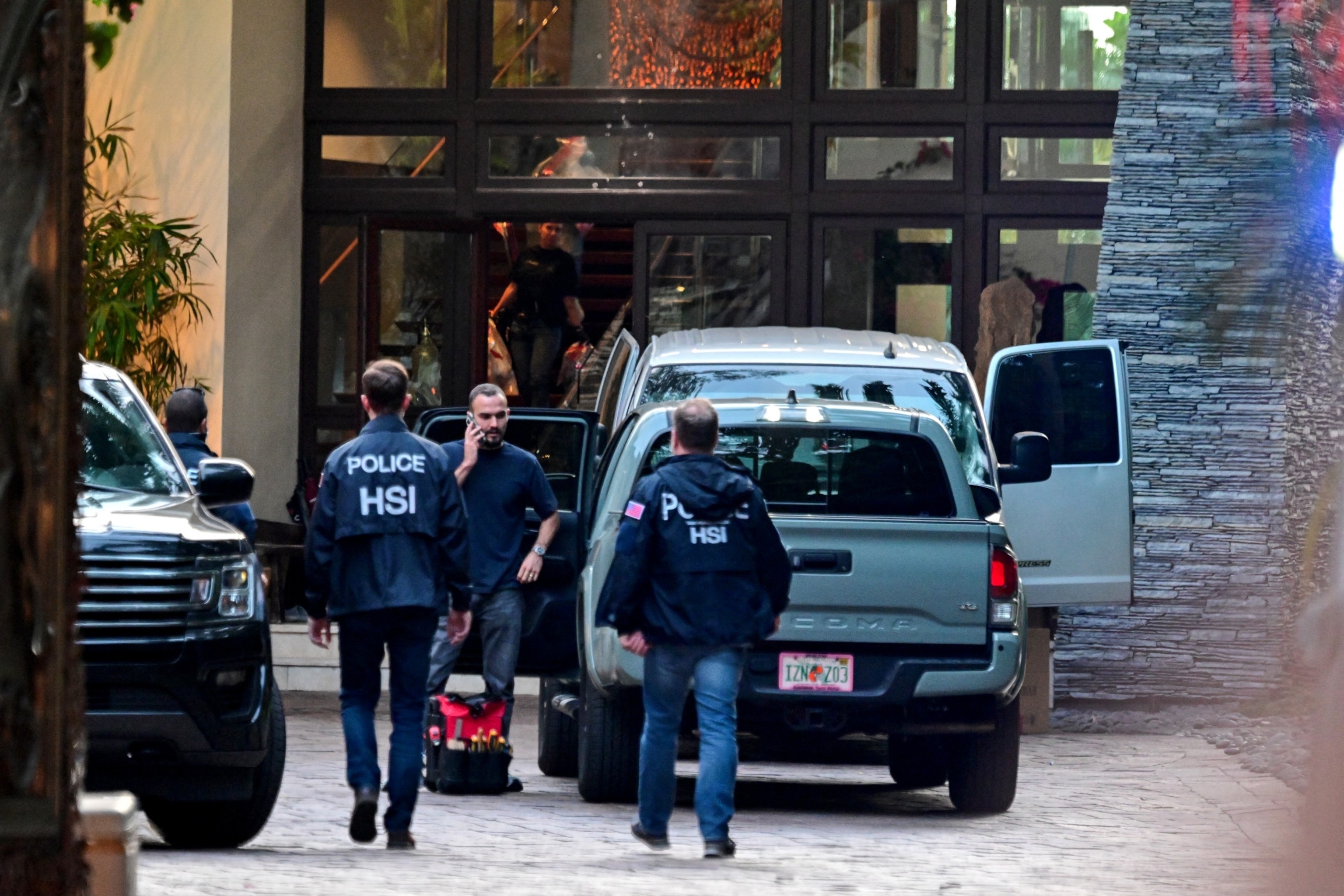PHOTO: Homeland Security Investigation agents are seen at the entrance of US producer and musician Sean "Diddy" Combs's home at Star Island in Miami Beach on March 25, 2024.