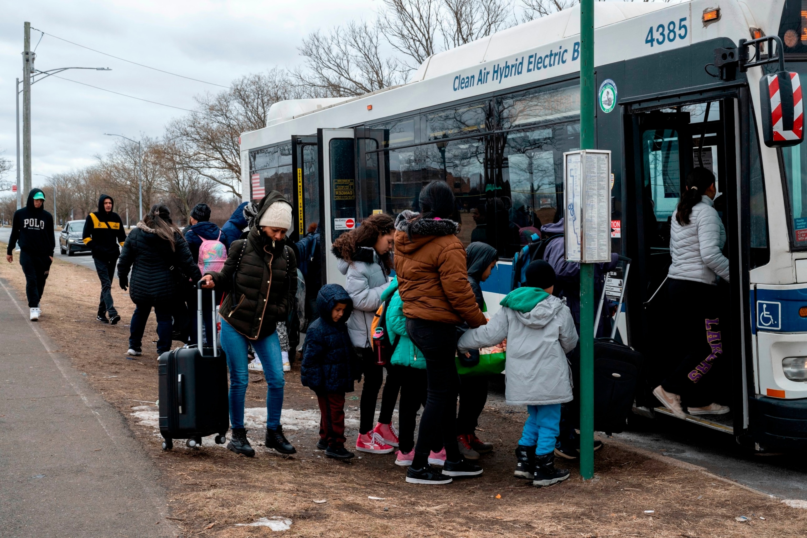 PHOTO: Recently arrived migrants get on a bus outside Floyd Bennett Field shelter on February 21, 2024 in Brooklyn, New York.
