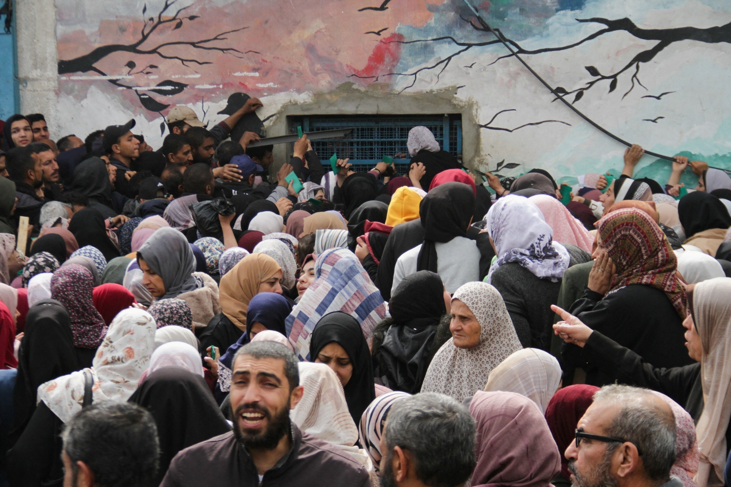 PHOTO: Palestinians gather to receive aid outside an UNRWA warehouse as Gaza residents face crisis levels of hunger in Gaza City, March 18, 2024. 