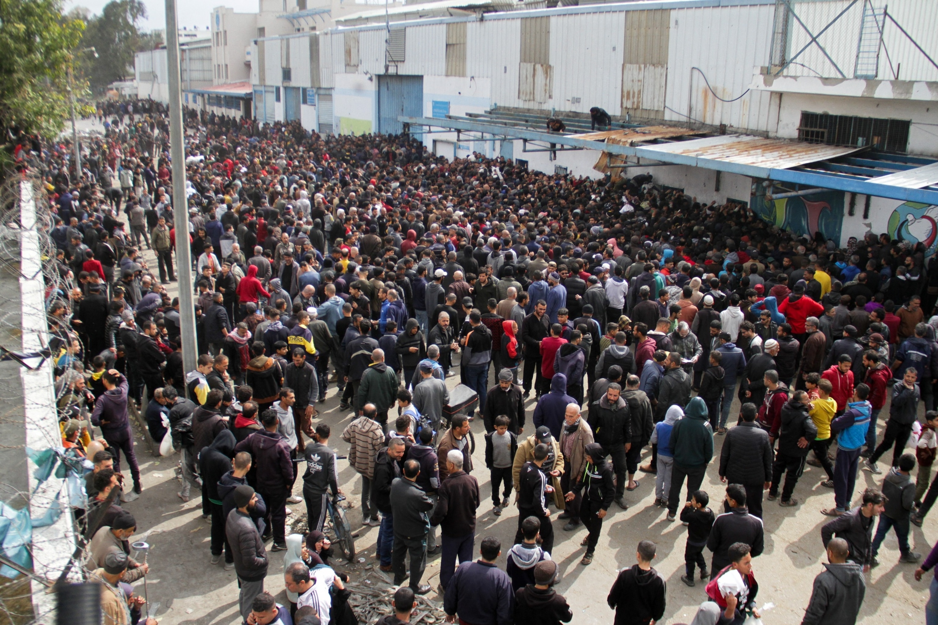 PHOTO: Palestinians gather to receive aid outside an UNRWA warehouse as Gaza residents face crisis levels of hunger in Gaza City March 18, 2024. 