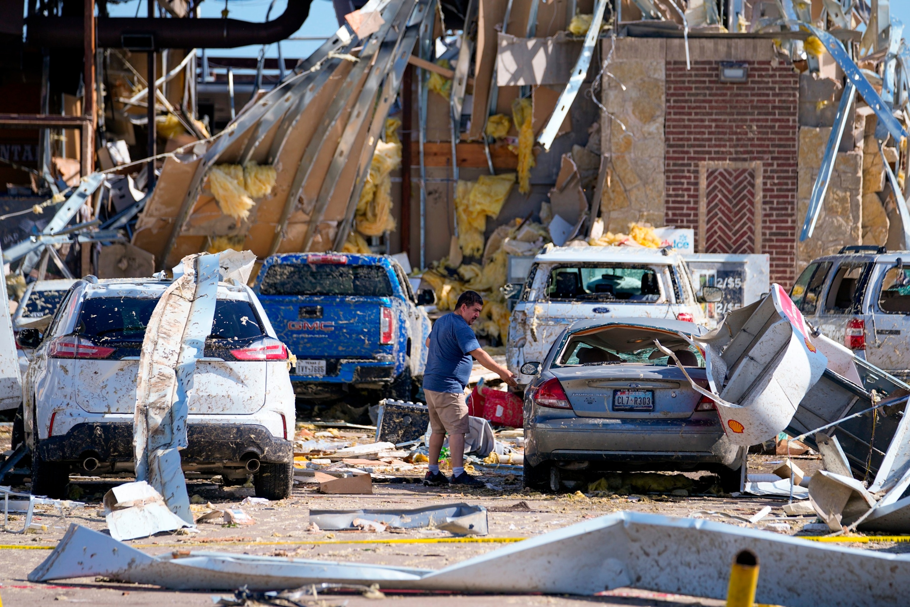 PHOTO: A man looks at a damaged car after a tornado hit the day before, May 26, 2024, in Valley View, Texas. 