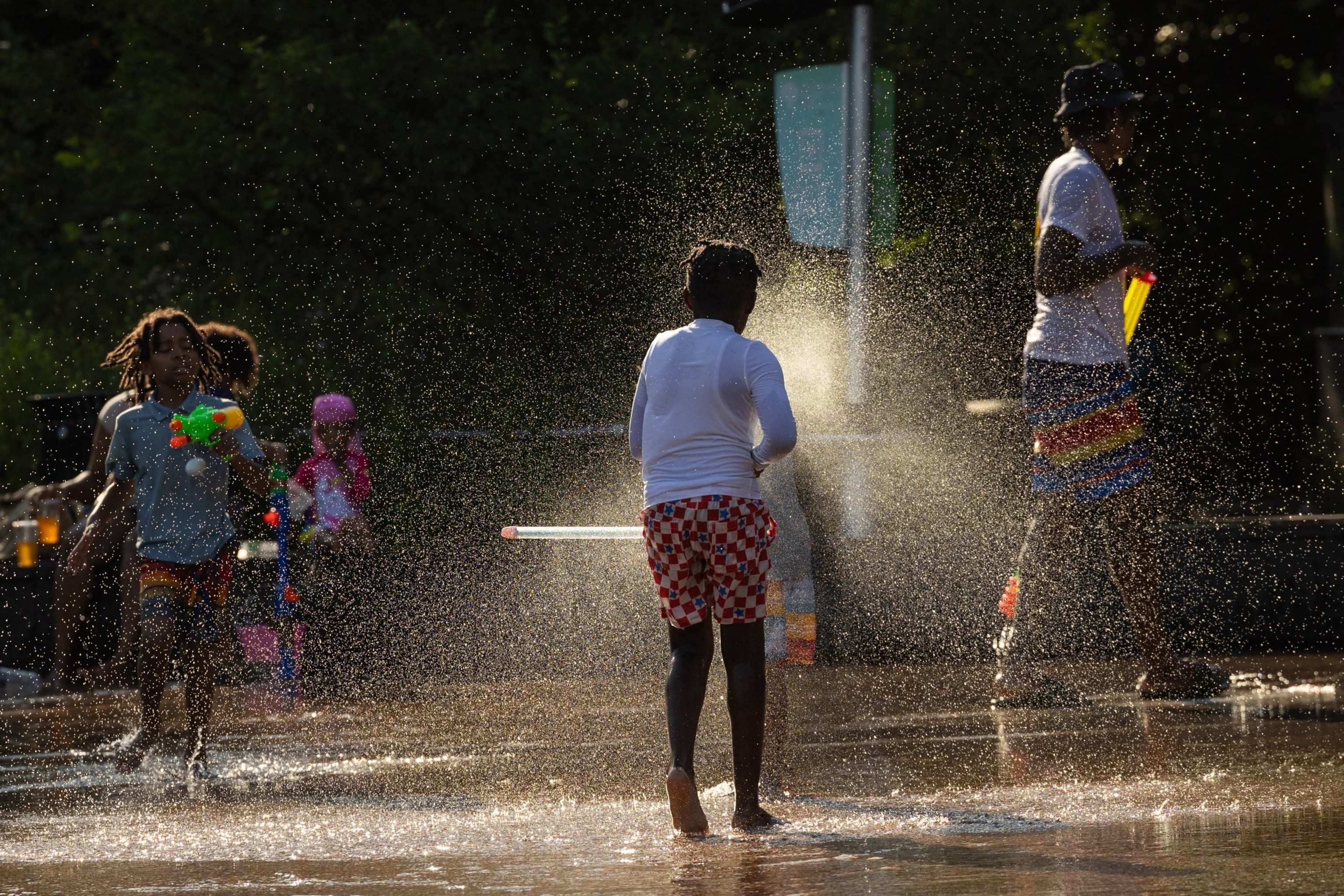 PHOTO: Children play with water guns at a splash pad at LeFrak Center at Lakeside at Prospect Park in Brooklyn, New York, June 20, 2024. 