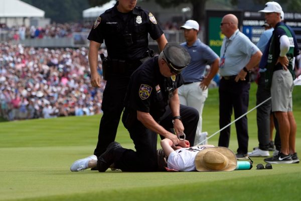 Climate protesters disrupt PGA Tour event by running onto 18th green and spraying powder, causing delay