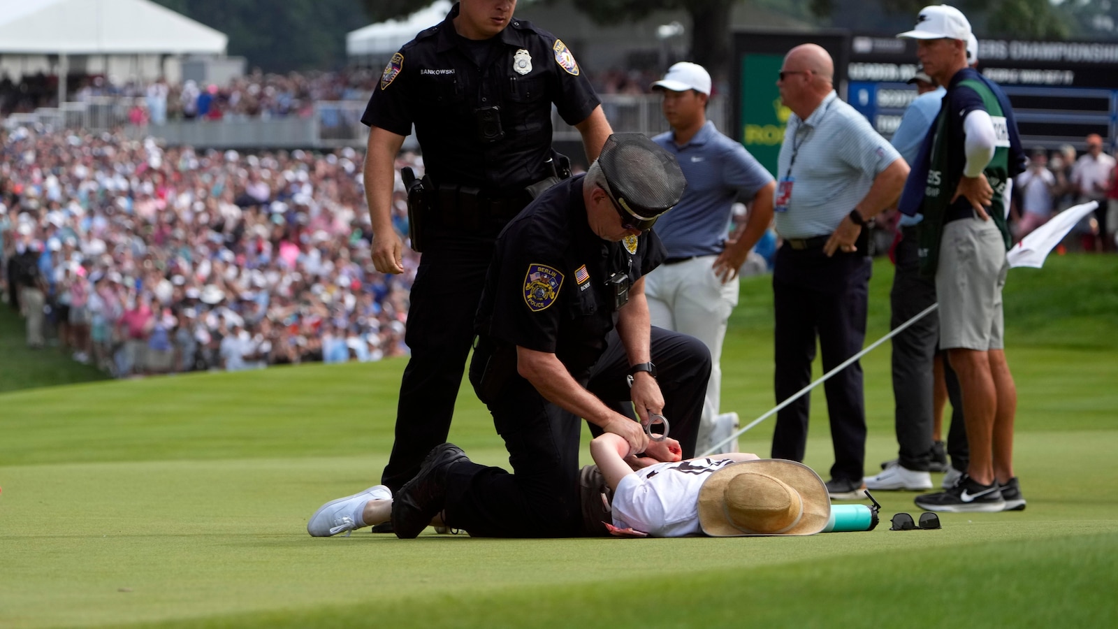 Climate protesters disrupt PGA Tour event by running onto 18th green and spraying powder, causing delay
