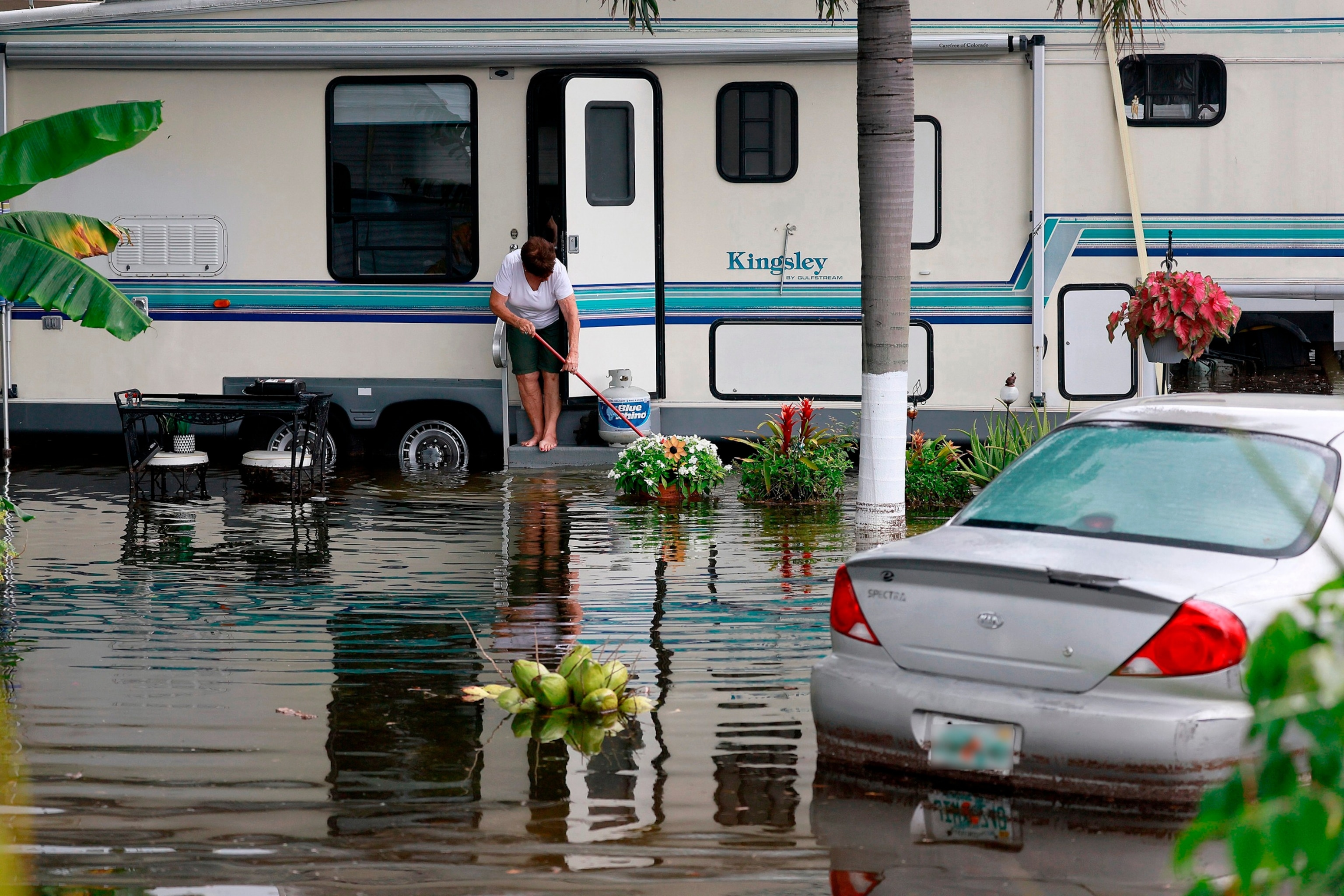 PHOTO: A woman sweeps out her home in the flooded Green Acres Village in Hallandale Beach, Florida, on June 13, 2024.