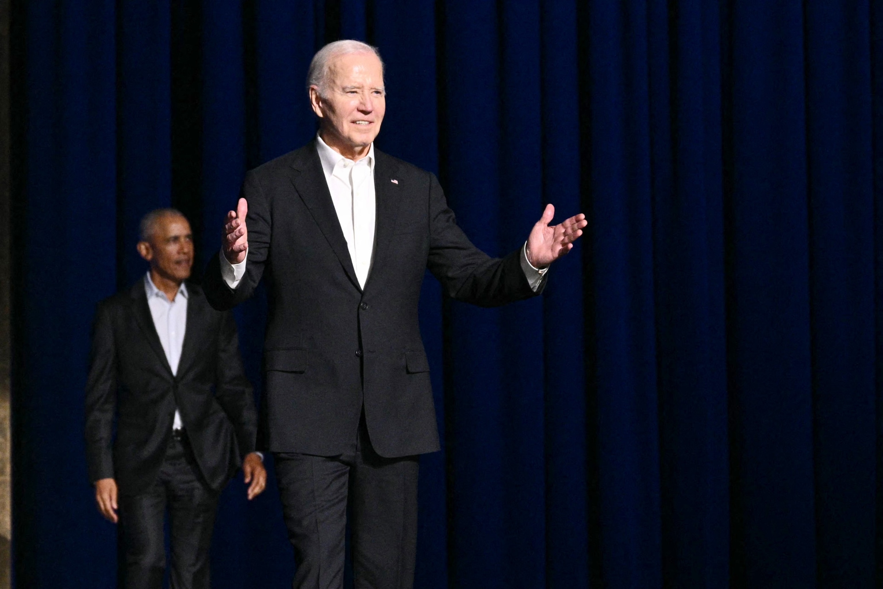 PHOTO: President Joe Biden (R) gestures as he arrives onstage with former President Barack Obama during a campaign fundraiser at the Peacock Theater in Los Angeles on June 15, 2024.