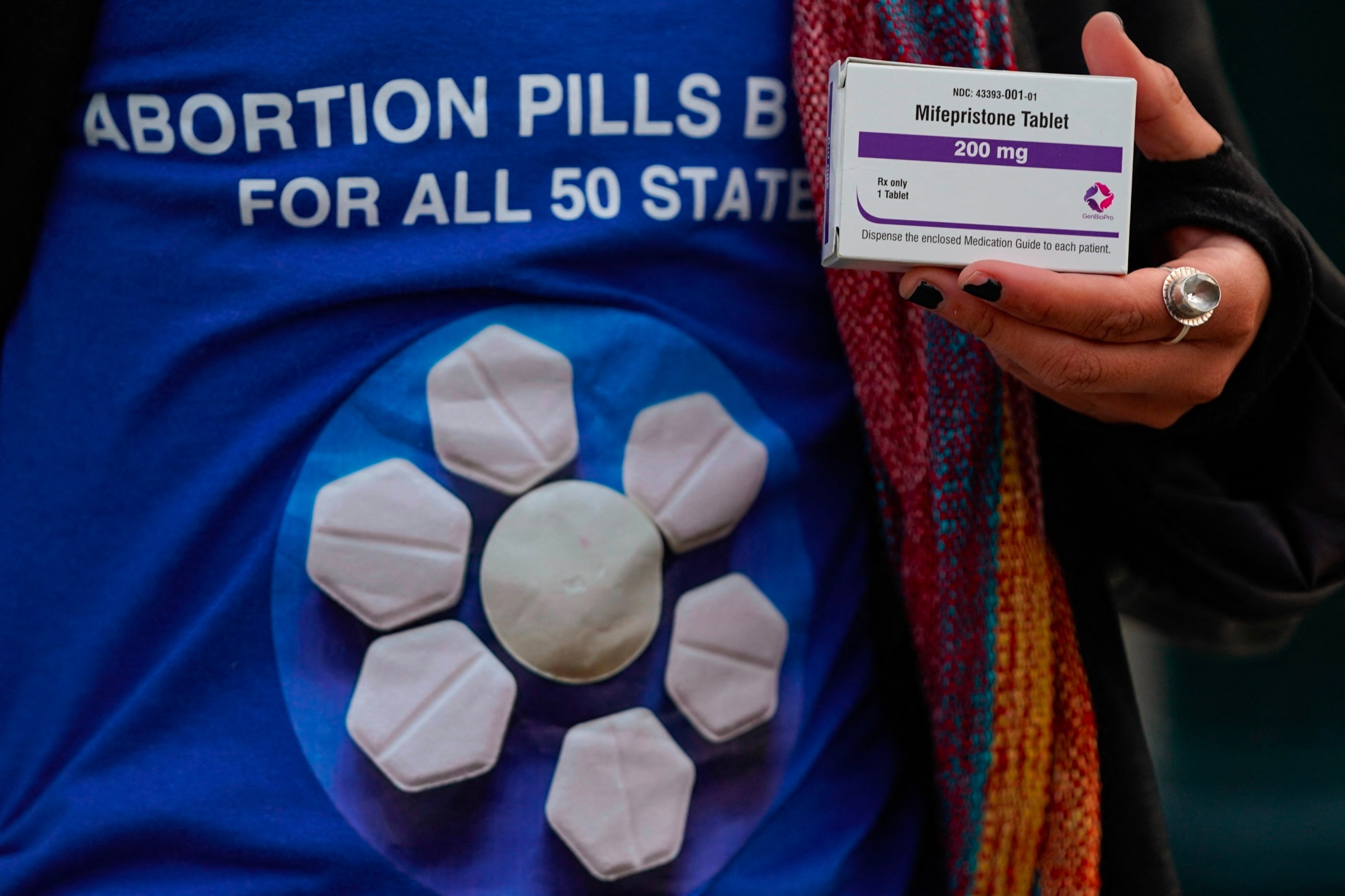 PHOTO: A pro-abortion rights activist holds a box of mifepristone during a rally in front of the US Supreme Court on March 26, 2024, in Washington, DC.