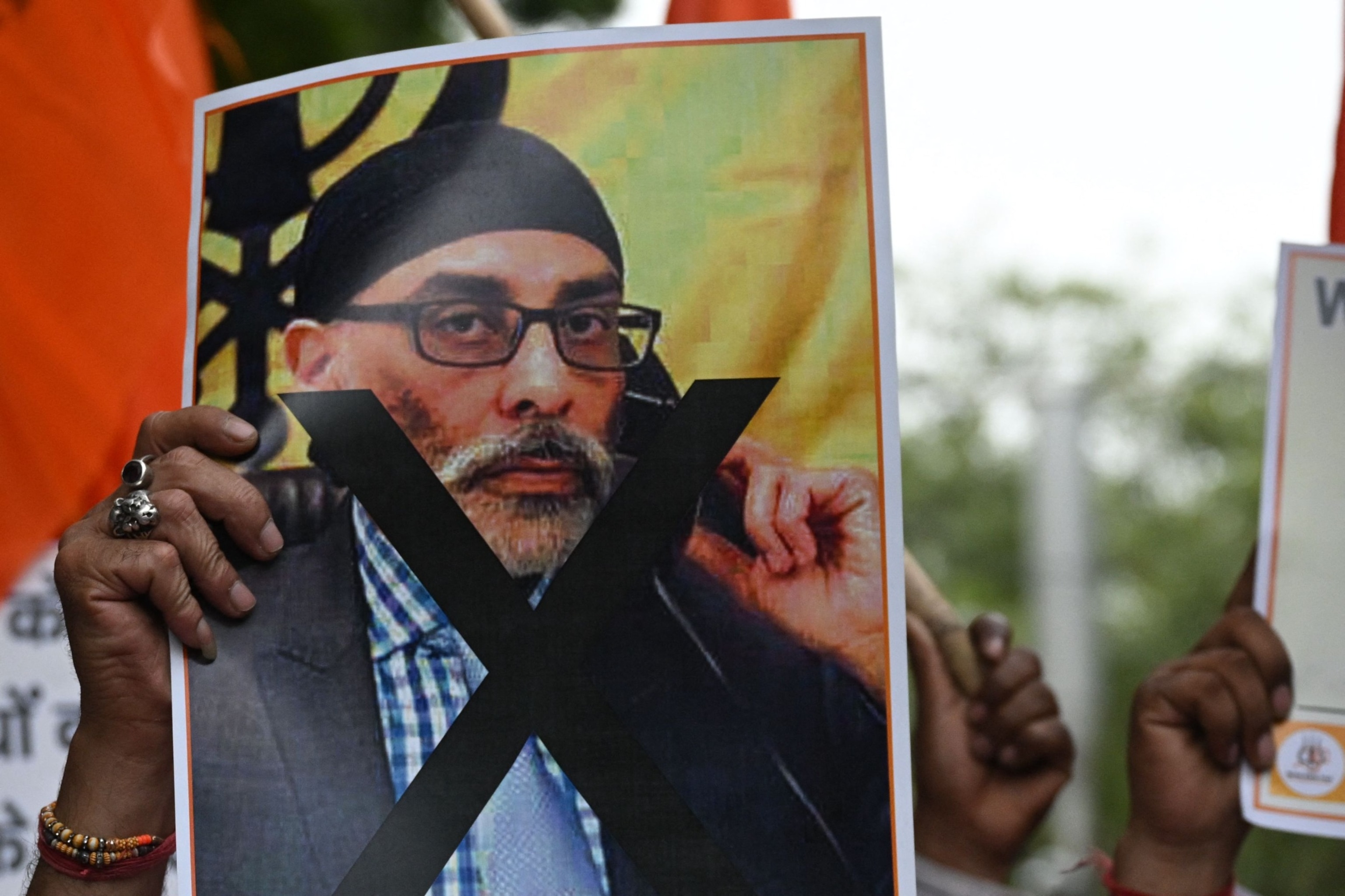 PHOTO: A member of United Hindu Front organization holds a banner depicting Gurpatwant Singh Pannun, a lawyer believed to be based in Canada during a rally along a street in New Delhi, Sept. 24, 2023.