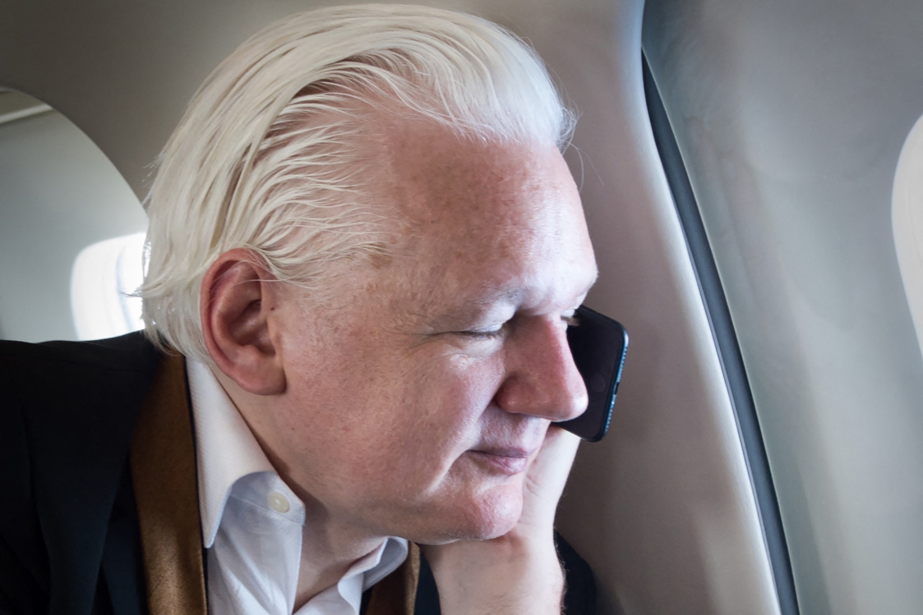 PHOTO: This handout photo courtesy of the WikiLeaks X and posted on June 26, 2024 shows WikiLeaks founder Julian Assange talking to his wife, Stella, while on his way in a private jet to Canberra after leaving Saipan in the Northern Mariana Islands. 