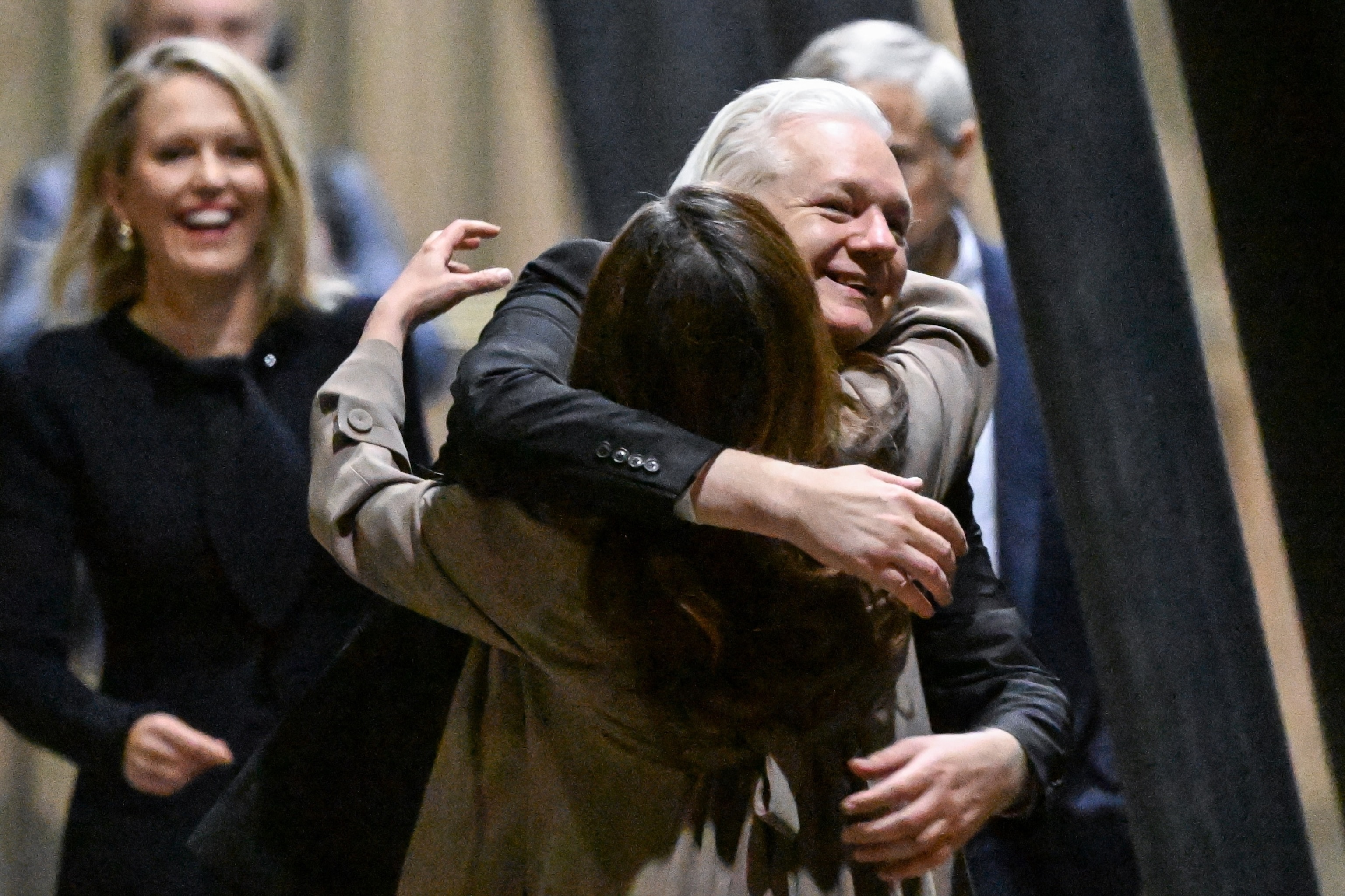 PHOTO: WikiLeaks founder Julian Assange hugs his wife, Stella Assange, after arriving at Canberra Airport in Canberra on June 26, 2024.