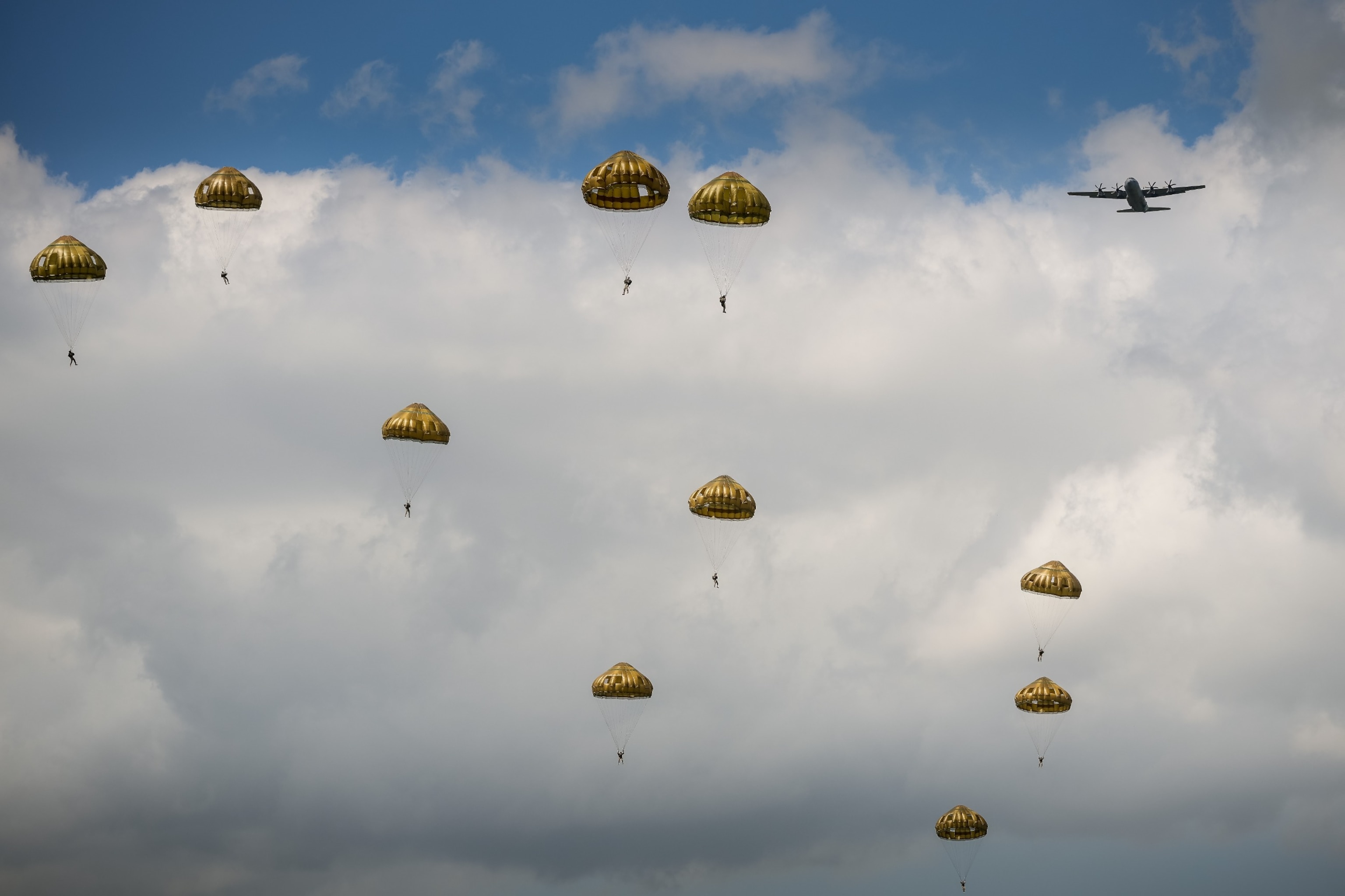 PHOTO: Paratroopers from the British, Belgian, Canadian and US military take part in a parachute drop in the fields of Sannerville as they reenact the D-Day landings of 80 years ago, June 5, 2024, in Sannerville, France. 