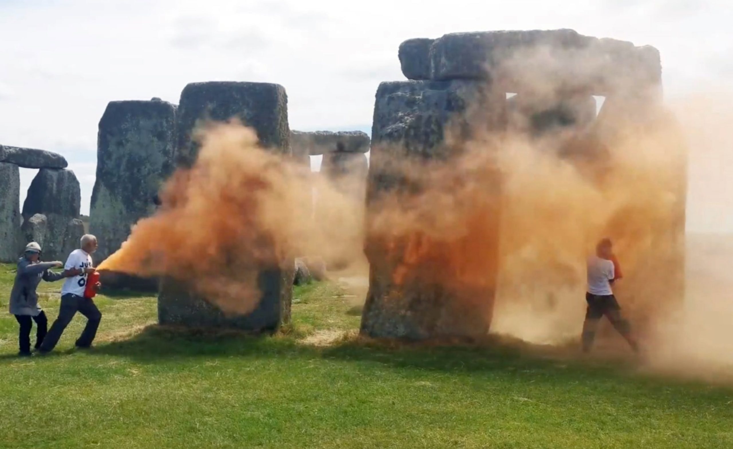 Protesters use orange powder paint to make a statement at Stonehenge in Britain