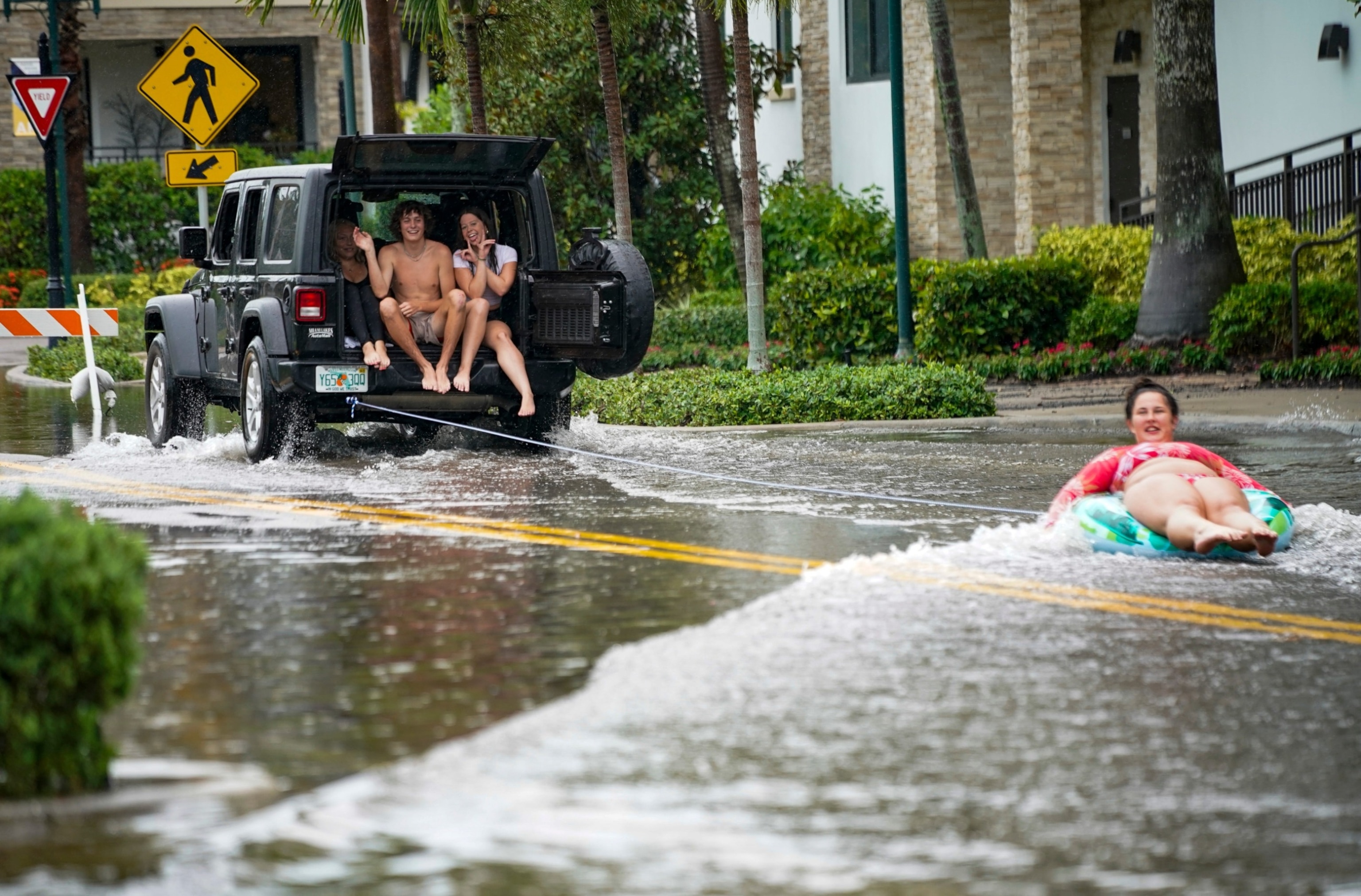 PHOTO: People traveling navigate flooded sections of streets as heavy rains continue for a third day in Naples on June 13, 2024.