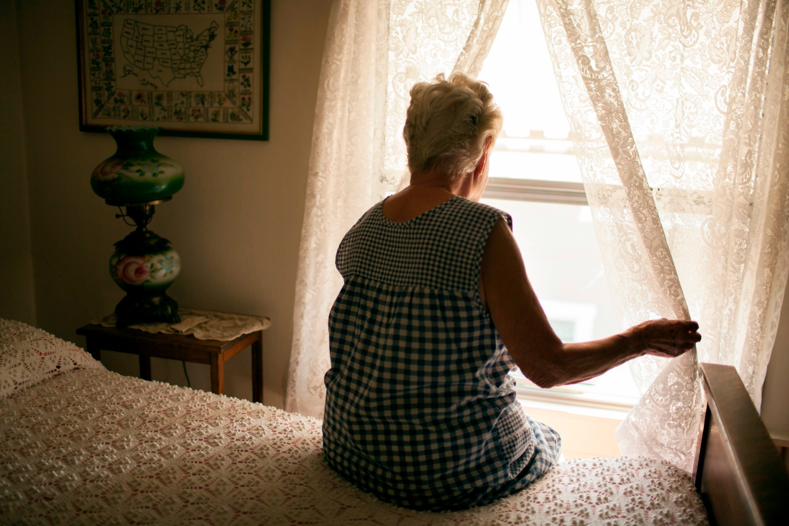 PHOTO: Stock photo of a senior woman looking out the window.