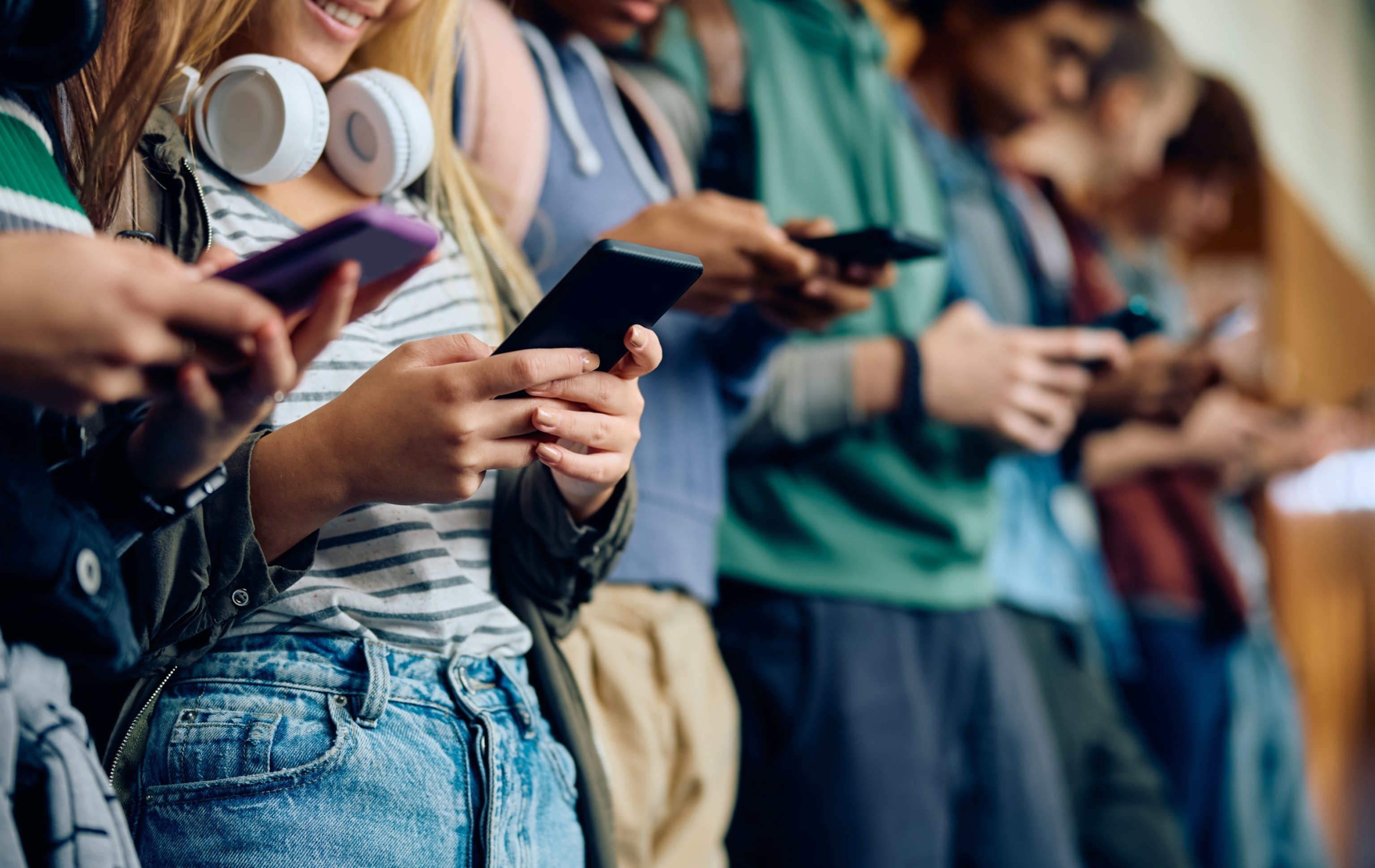 PHOTO: Teenage girl and her friends using mobile phones at high school hallway in this undated stock photo.