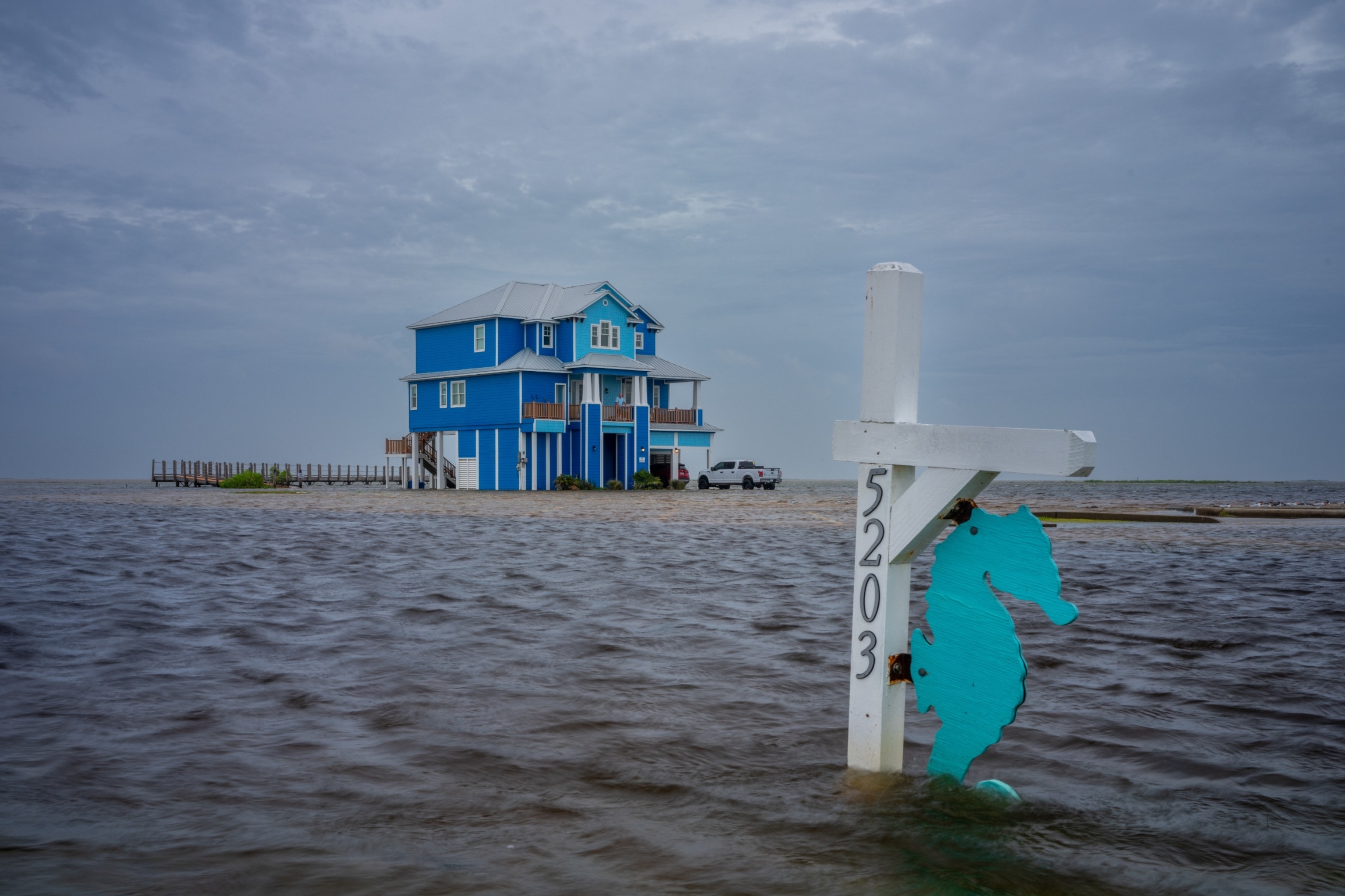 PHOTO: A person looks out from their balcony over floodwater on June 19, 2024 in Surfside Beach, Texas.
