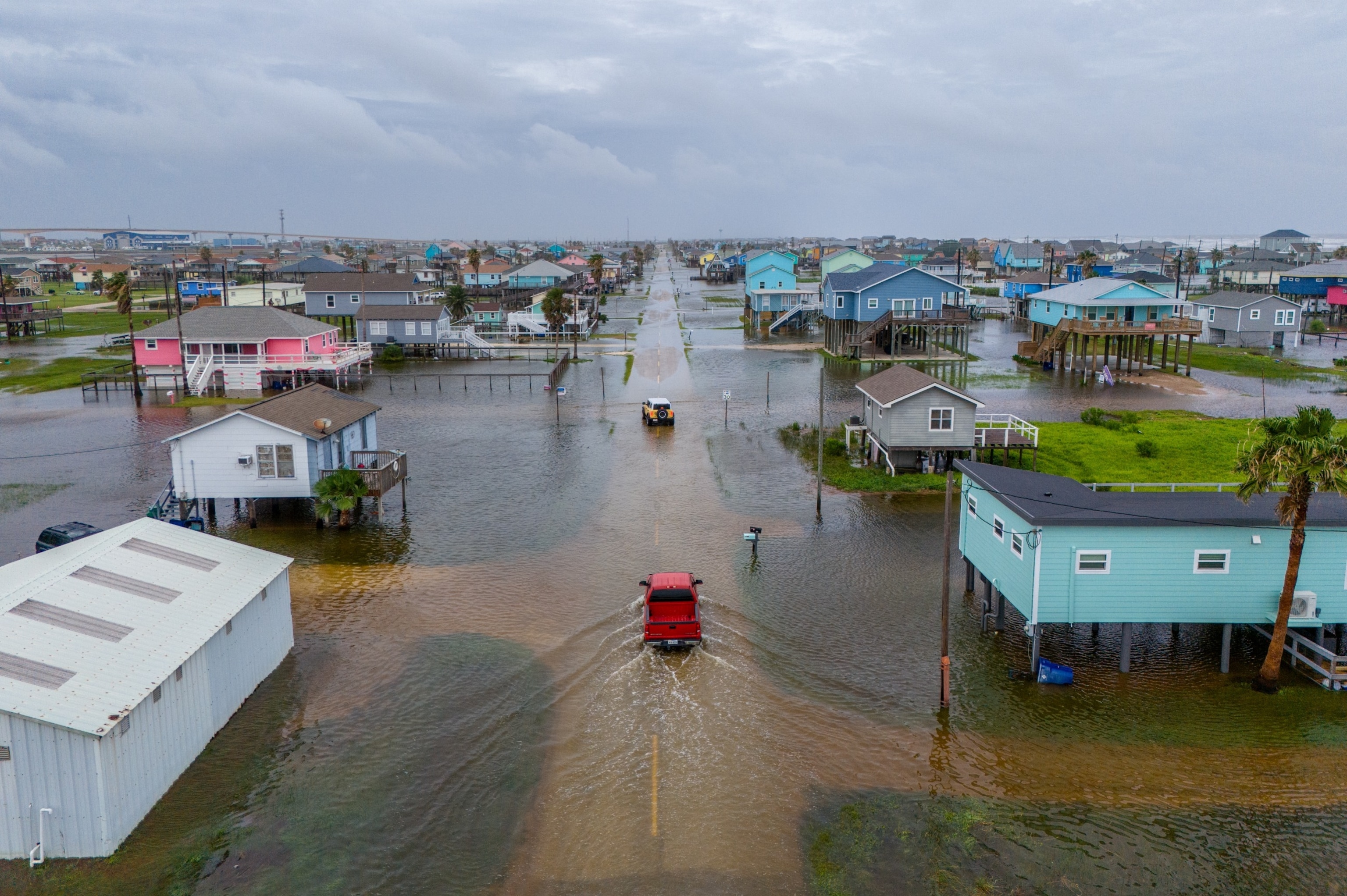 PHOTO: In this aerial image, vehicles drive through flooded neighborhoods on June 19, 2024 in Surfside Beach, Texas. 
