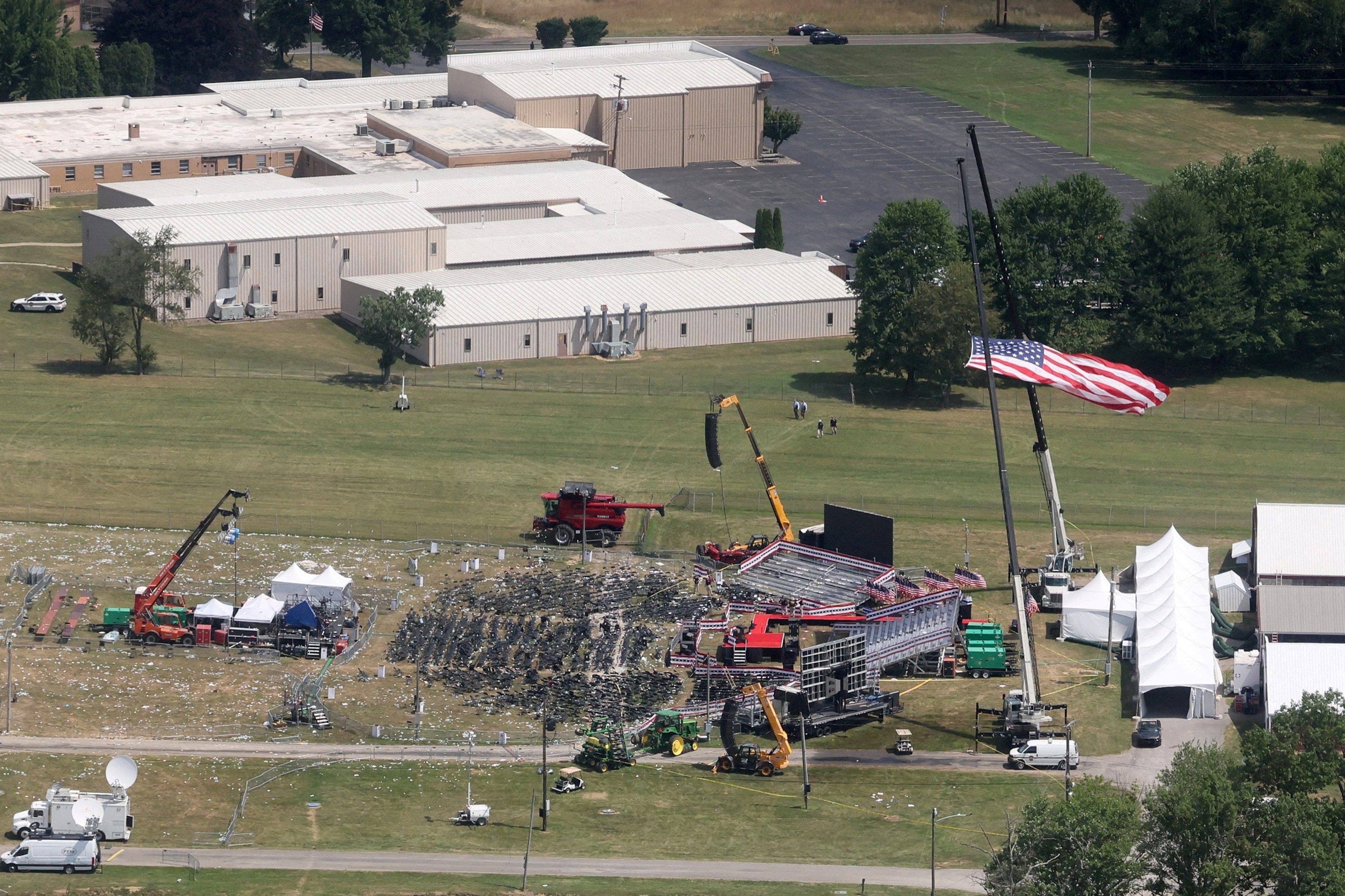 PHOTO: The stage where former President Donald Trump had been standing during an assassination attempt the day before, and the roof of a nearby building where a gunman was shot dead by law enforcement, in Butler, Pennsylvania, July 14, 2024.  