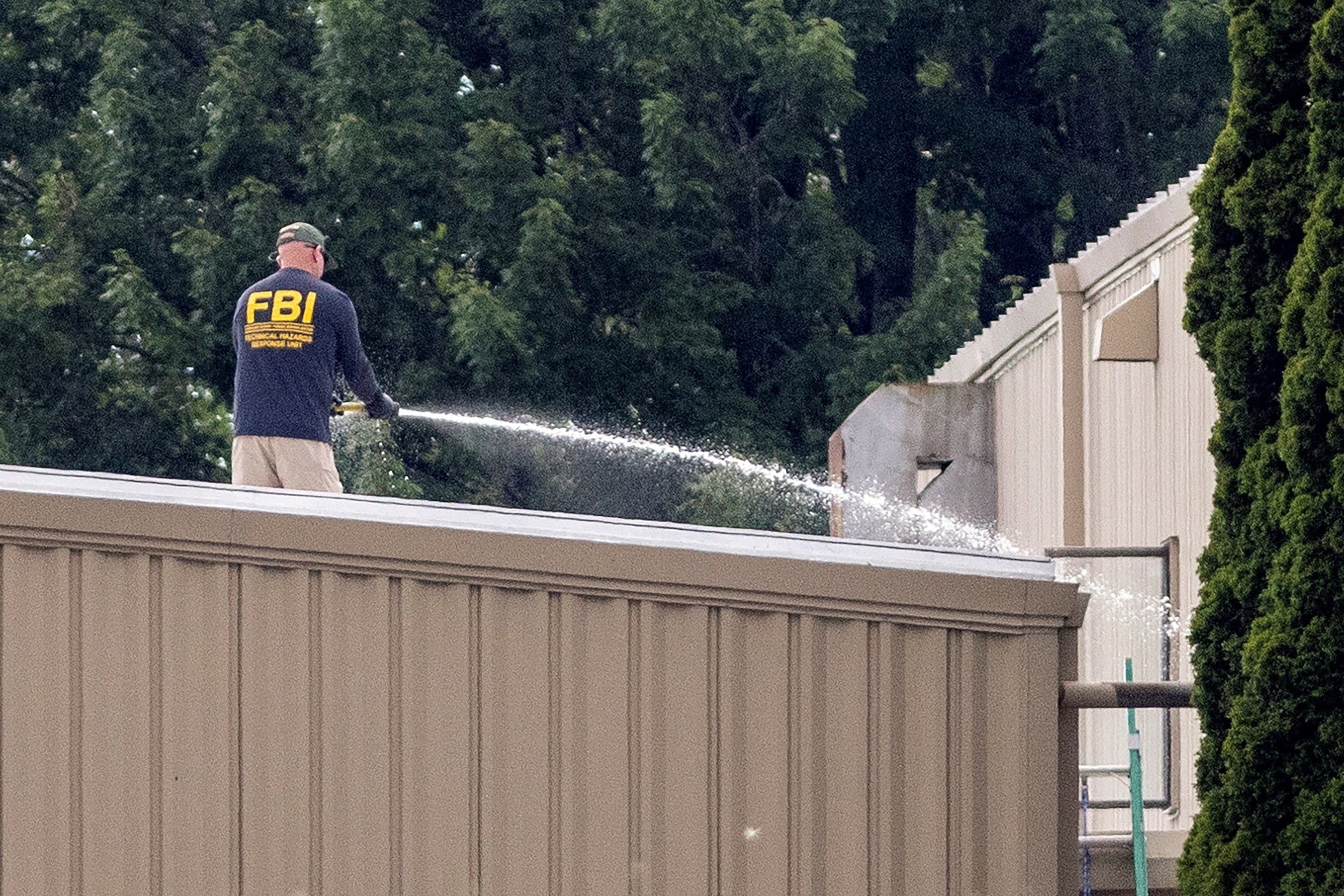 PHOTO: An FBI investigator hoses off a rooftop where a gunman had been positioned during former U.S. President Donald Trump's campaign rally in Butler, Pennsylvania, on July 14, 2024.