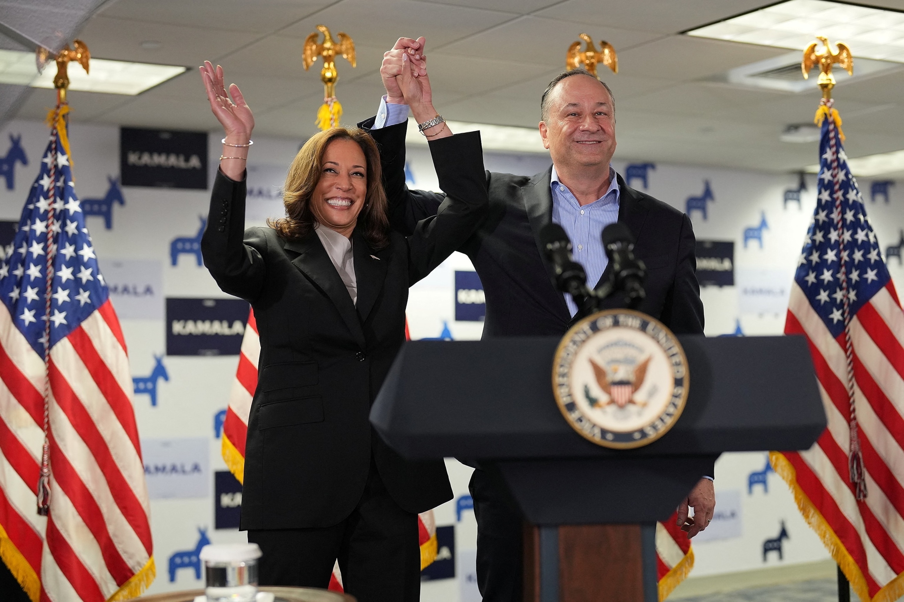 PHOTO: Vice President Kamala Harris and second gentleman Douglas Emhoff gesture as they arrive at Kamala's Presidential Campaign headquarters in Wilmington, Del.,  July 22, 2024. 