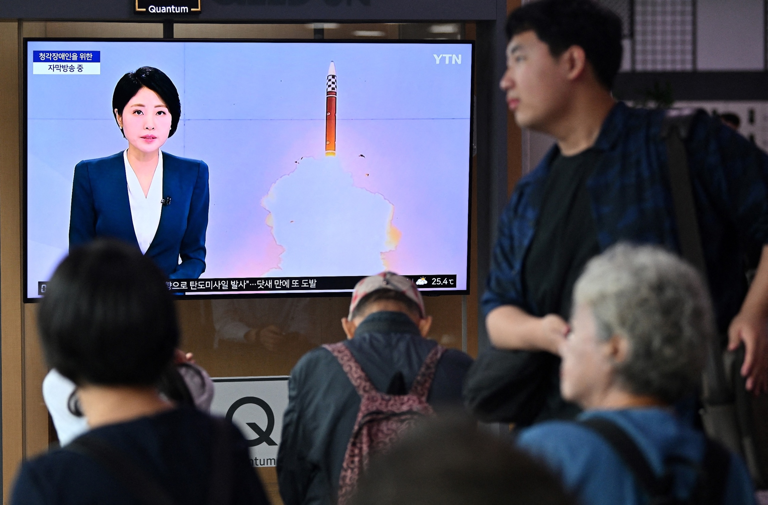 PHOTO: A man walks past a television screen showing a news broadcast with file footage of a North Korean missile test, at a train station in Seoul on July 1, 2024.
