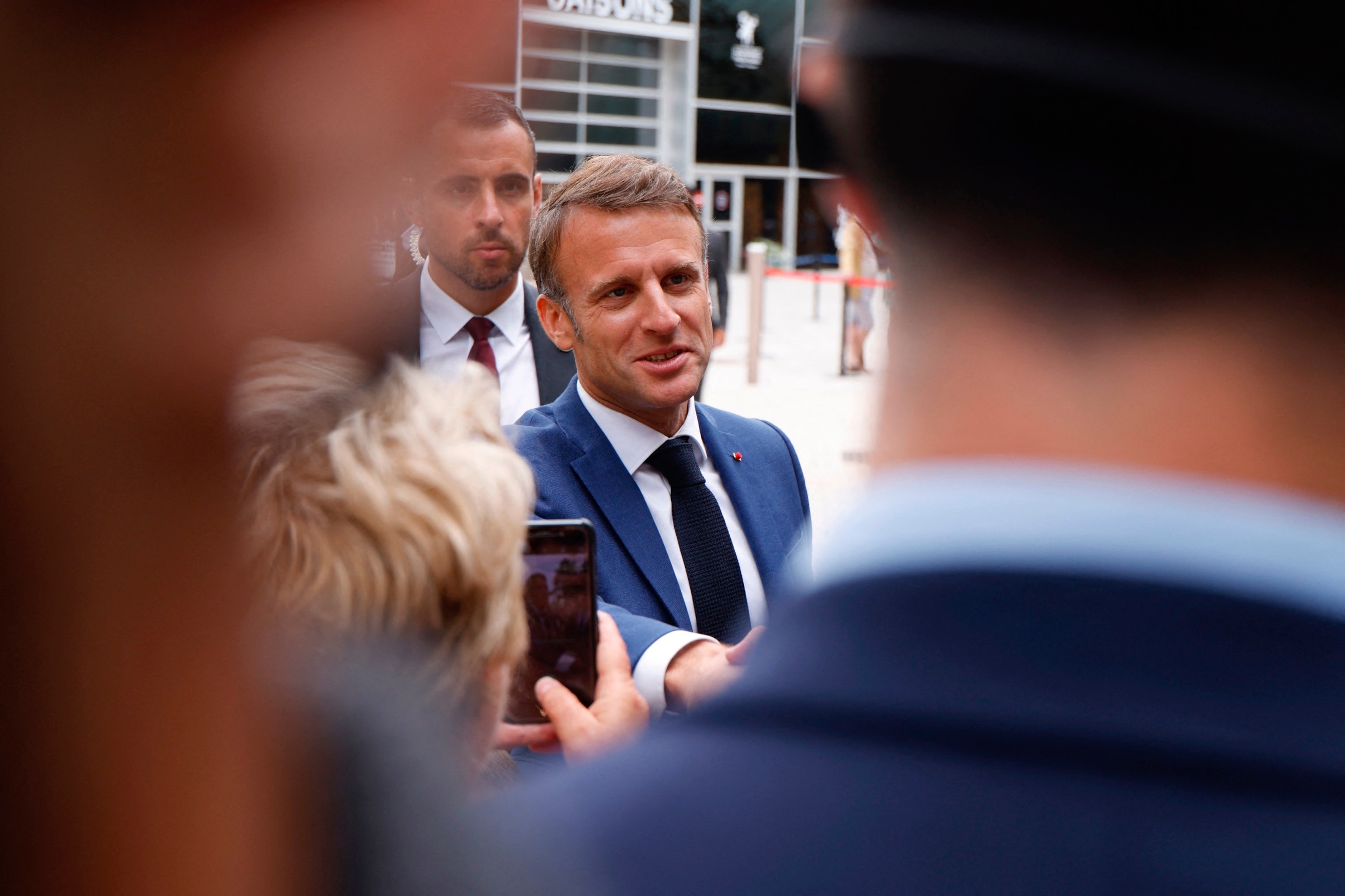 PHOTO: France's President Emmanuel Macron shakes hands with supporters after voting in the first round of parliamentary elections outside a polling station in Le Touquet, northern France, on June 30, 2024.