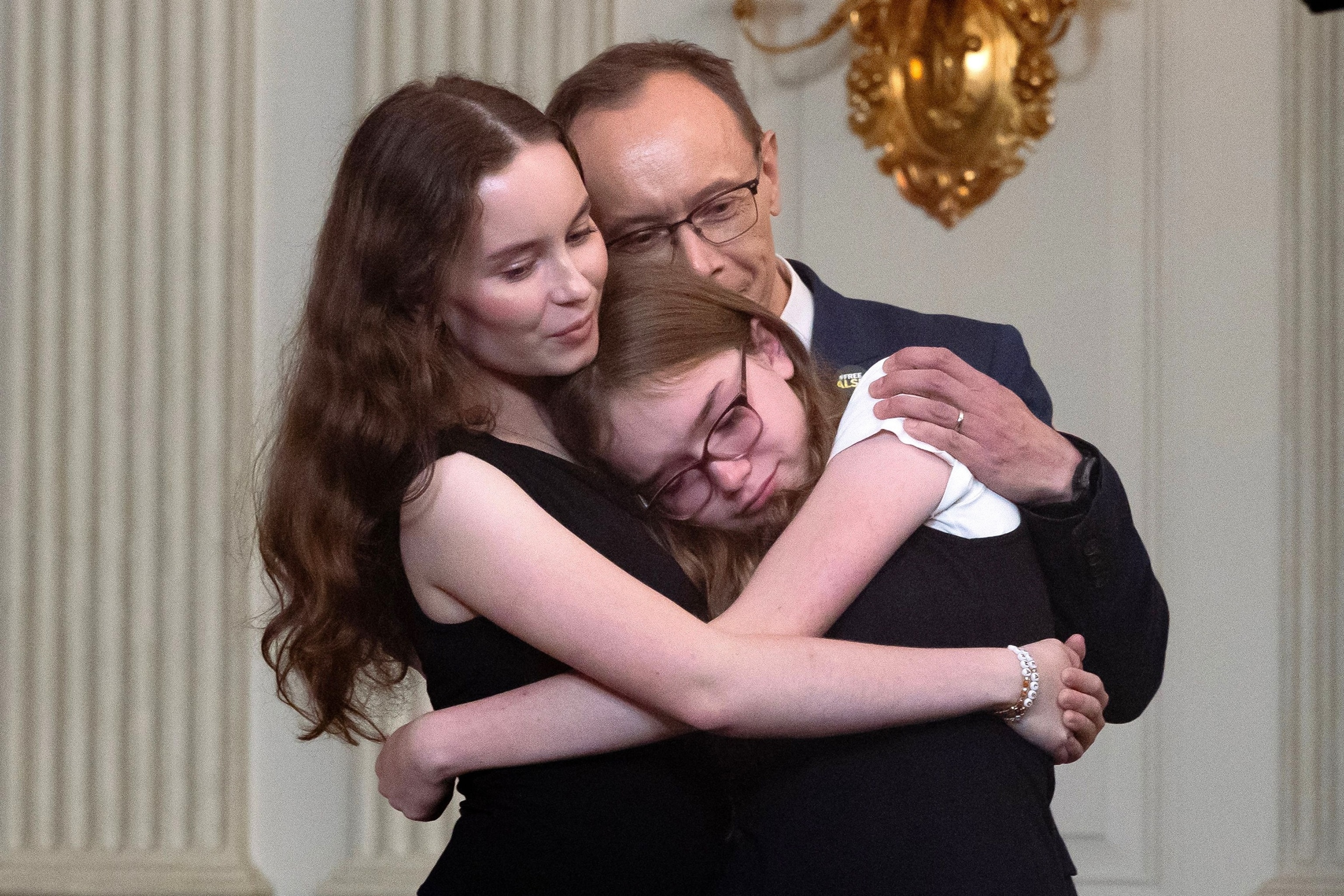 PHOTO: The family of Alsu Kurmasheva embrace while listening to US President Joe Biden speaking on a prisoner swap with Russia, in the State Dining Room of the White House in Washington, D.C., on Aug. 1, 2024.