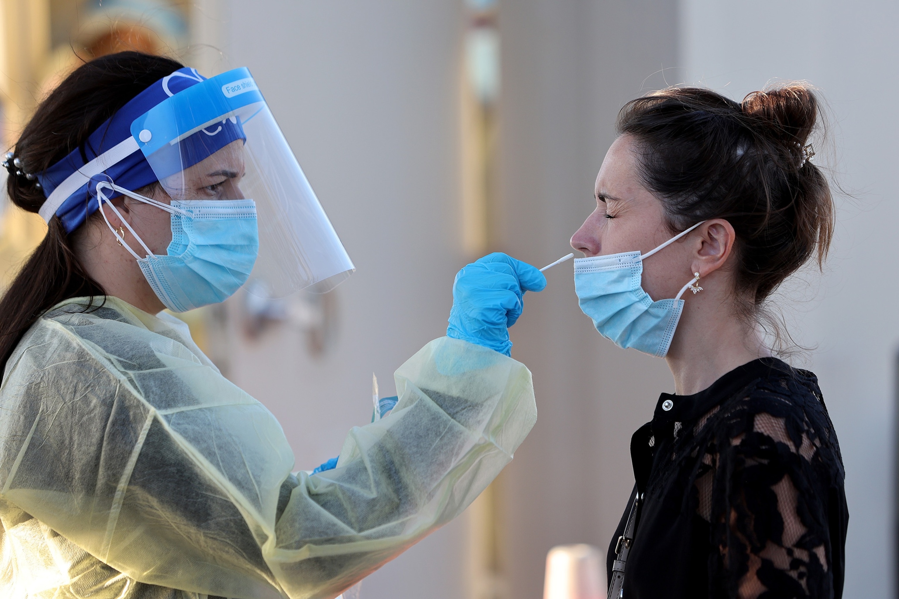 PHOTO: Jordane Domain gets a COVID-19 test done by a healthcare worker on Jan.  13, 2022 in North Miami, Fla.