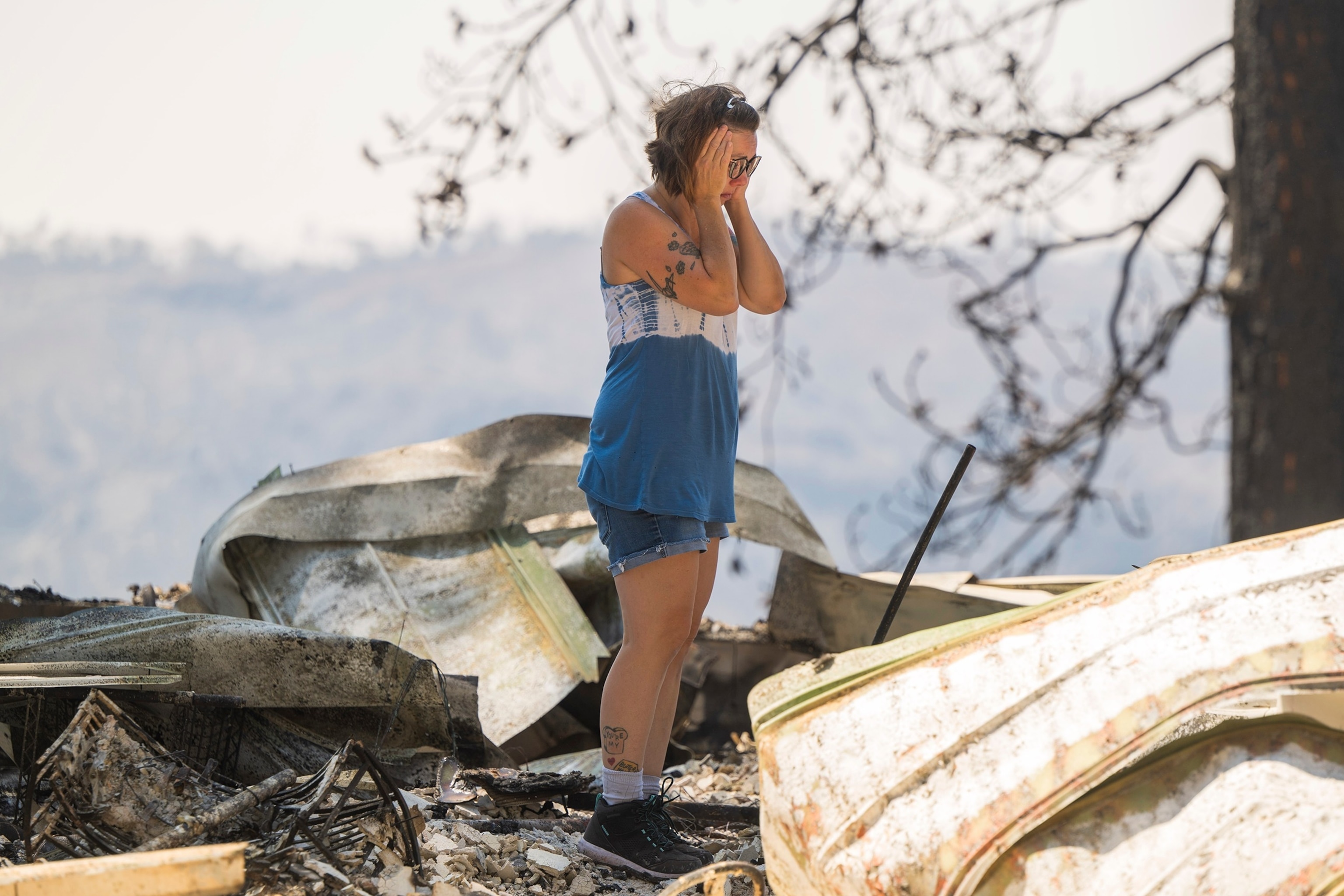 PHOTO: Andrea Blaylock becomes emotional as she sifts through the charred remains of her home that was destroyed in the Park Fire near Forest Ranch, Calif.,  July 30, 2024.