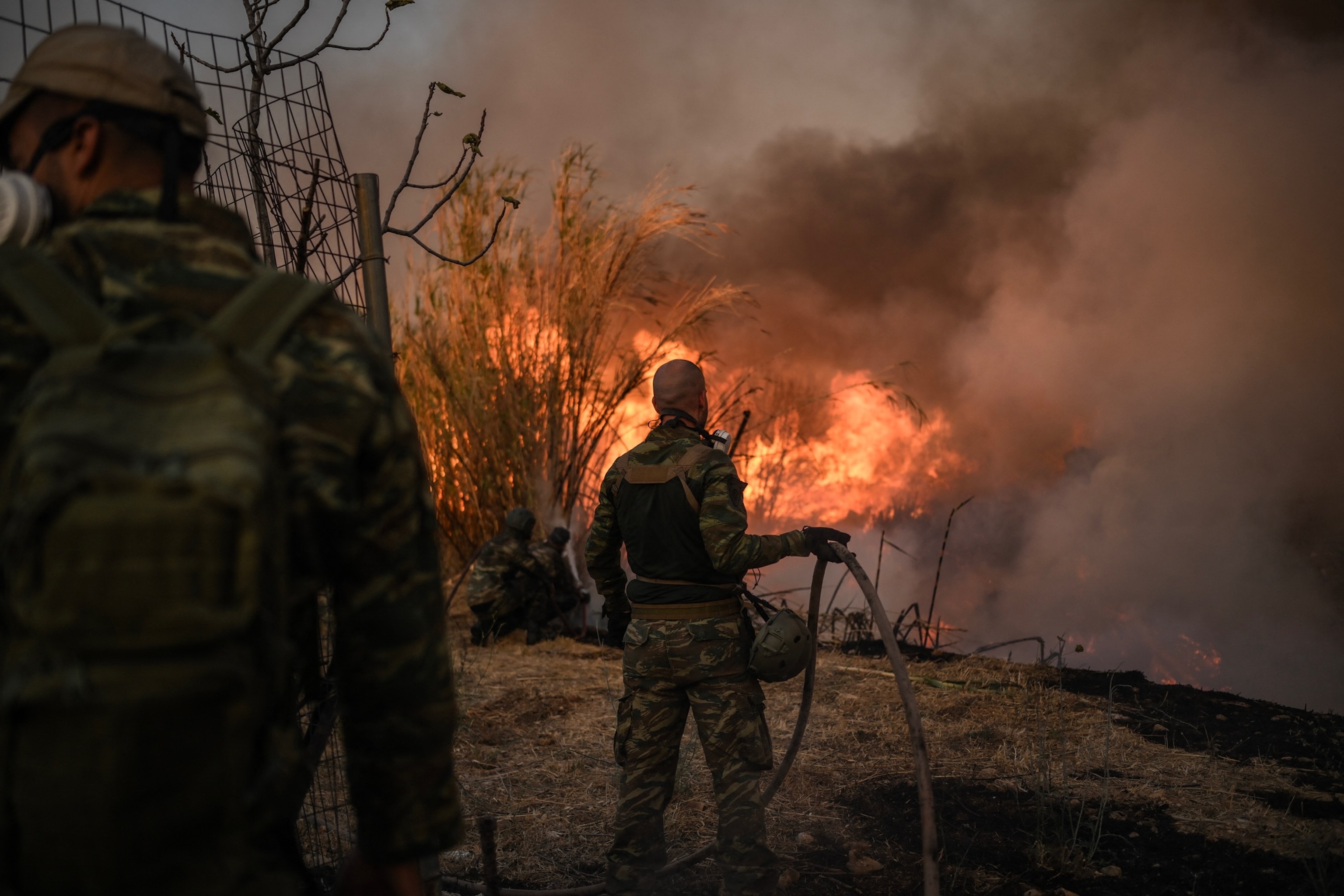 PHOTO: Volunteers fight a wildfire near Penteli, on August 12, 2024. Greece's civil protection authorities ordered the evacuation of several towns in the north-eastern suburbs of Athens, threatened by a violent fire that started the day before.