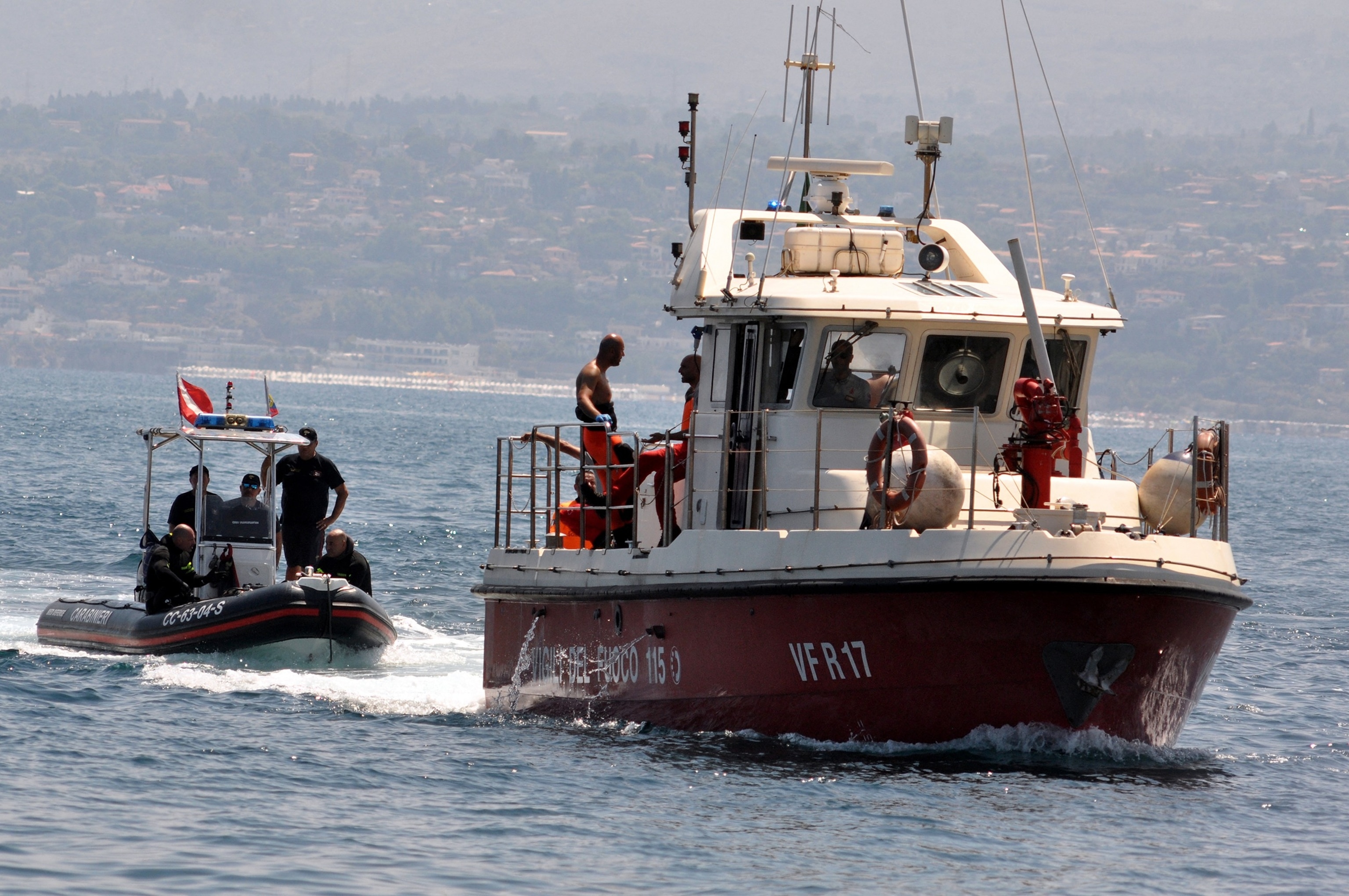 PHOTO: Divers of the Vigili del Fuoco, the Italian Corps. of Firefighters enter Porticello harbor near Palermo, with the body of the last missing person at the back of the boat, on Aug. 23, 2024.