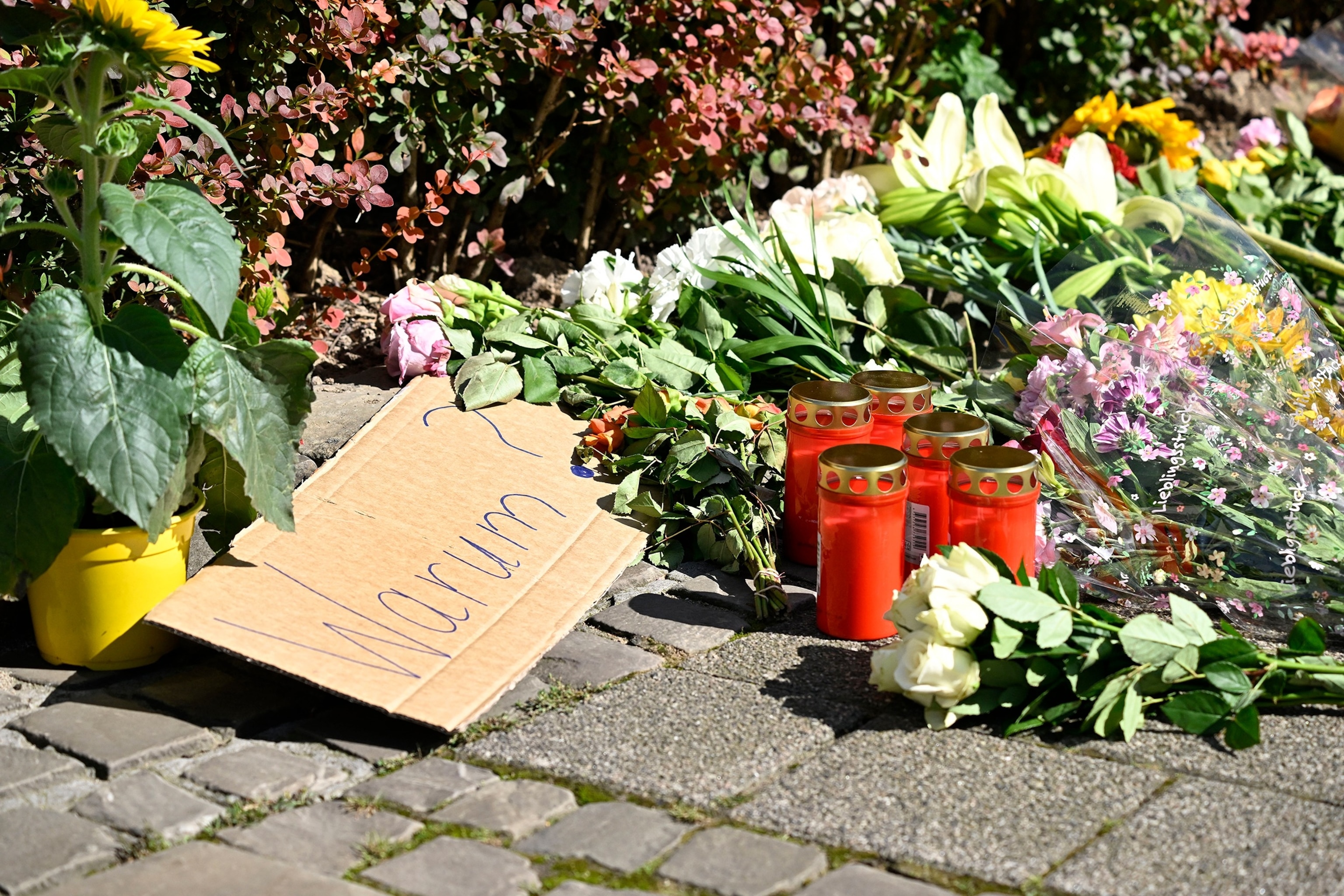 PHOTO: A sign reading "Why?" lies at a makeshift memorial on Aug. 24, 2024, near the scene where at least three people were killed and several injured when a man attacked them with a knife  in Solingen, western Germany.