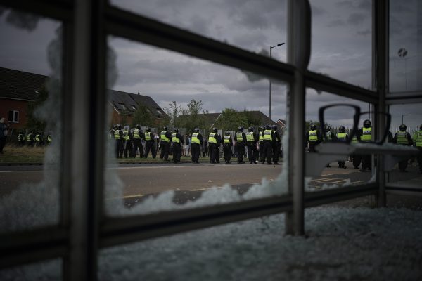 Police in the UK engage in confrontation with rioters following a fatal knife attack at a dance event.