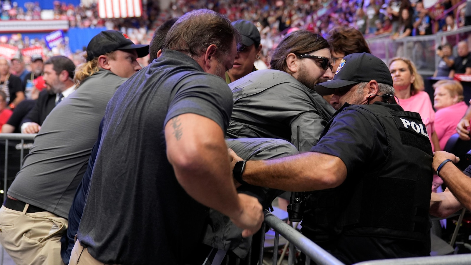 Police arrest man attempting to hang protest banner at Trump rally