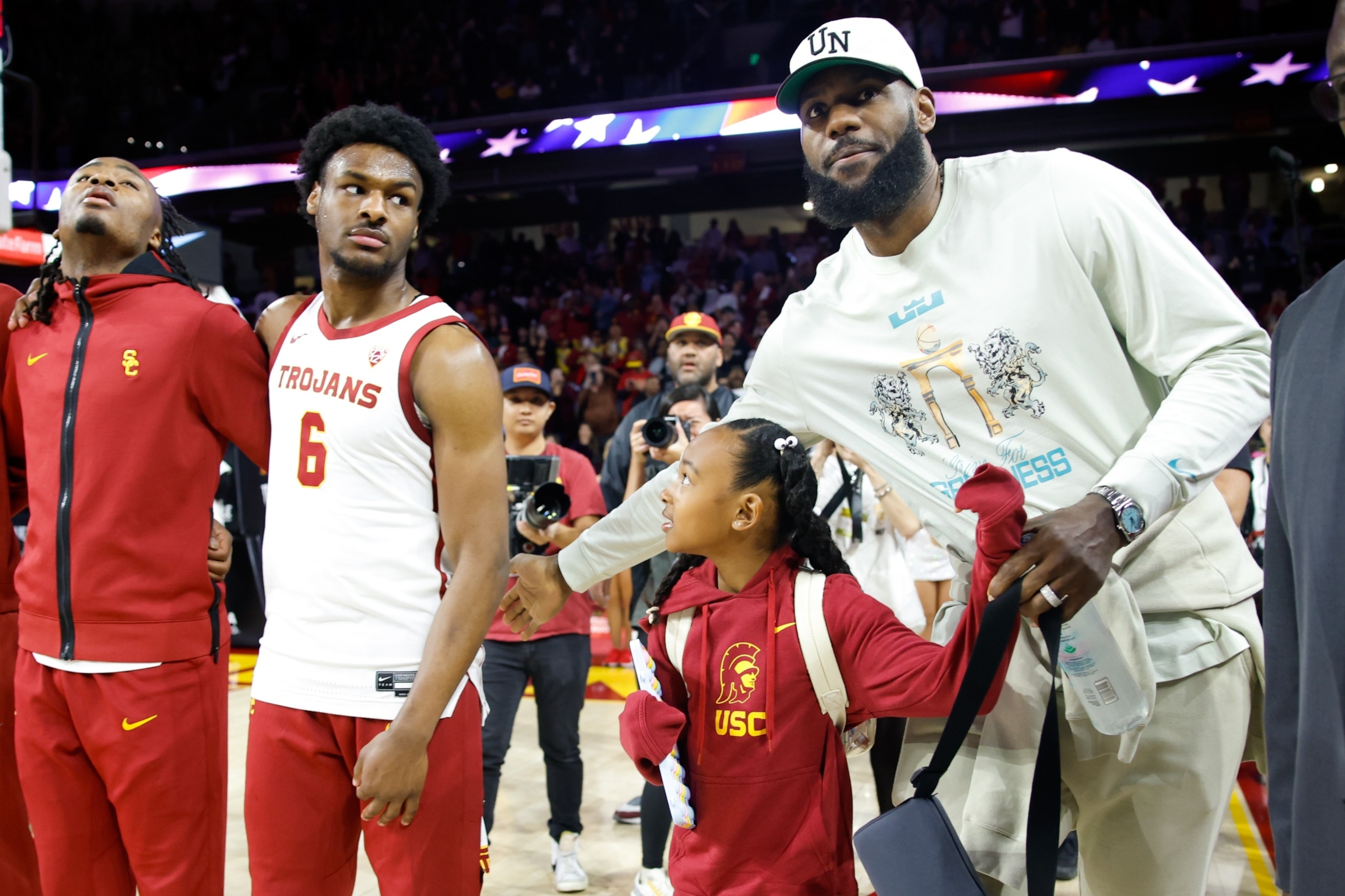 PHOTO: Los Angeles Lakers' LeBron James pats the back of USC Trojans guard Bronny James before the game against the Long Beach State 49ers in Los Angeles Dec. 10, 2023. 